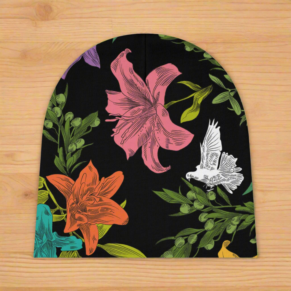 A black, knit, baby beanie with multi-colored, all-over print of doves, flowers, and olive branches, without a folded brim.