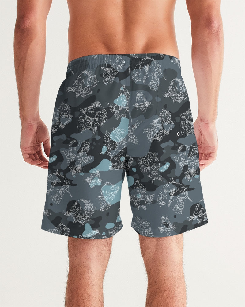 The back view of a male model wearing a pair of blue camo board shorts with an all-over swimming carp print in a white pattern.
