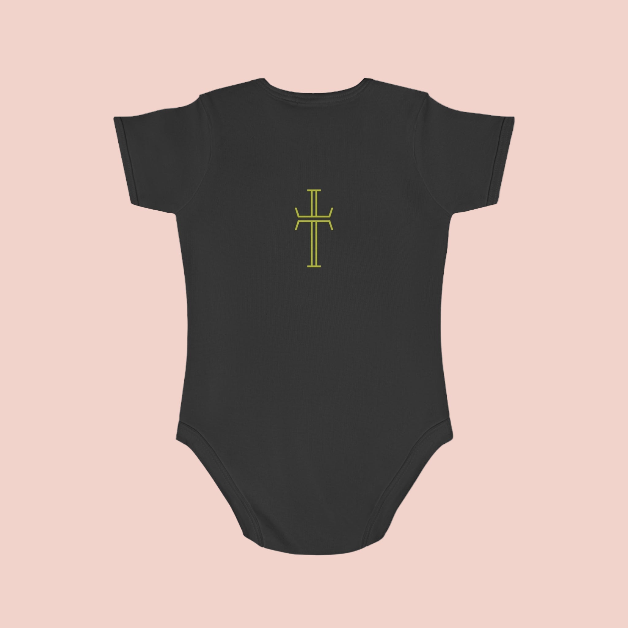 Black baby onesie with a yellow cross design on a pale pink background