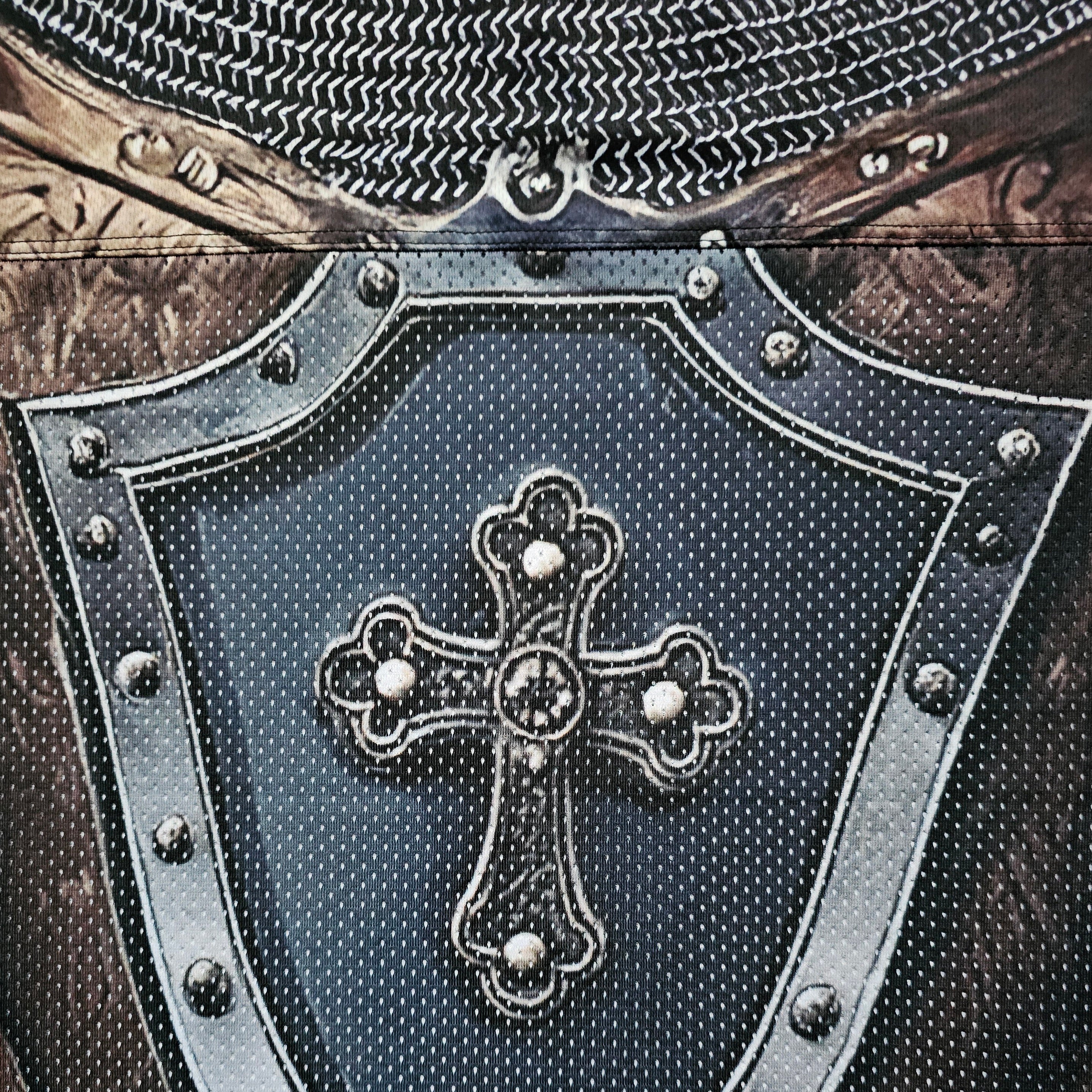 Close-up of a decorative cross on a football jersey with metallic accents