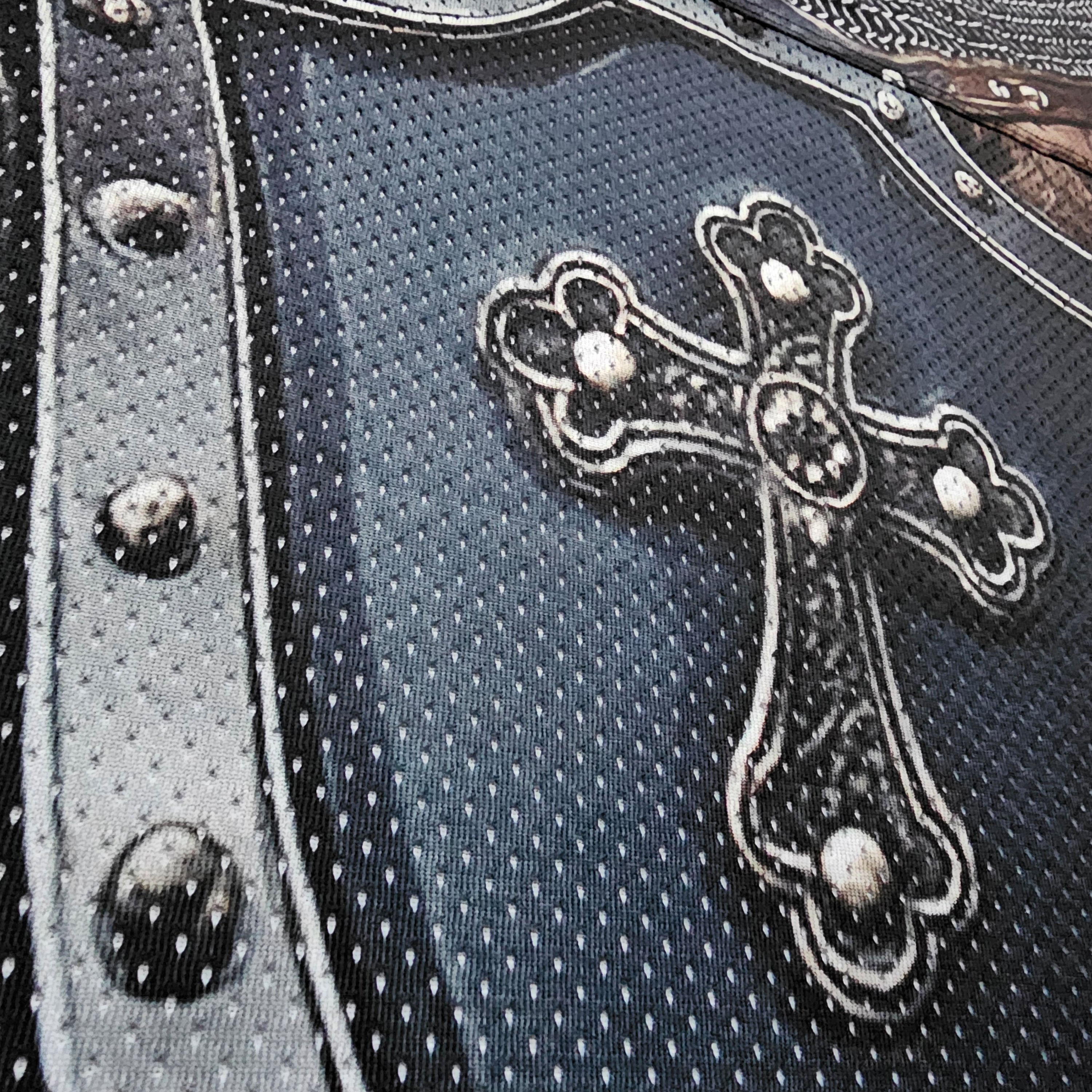 Close-up of a cross design on a football jersey with metallic accents