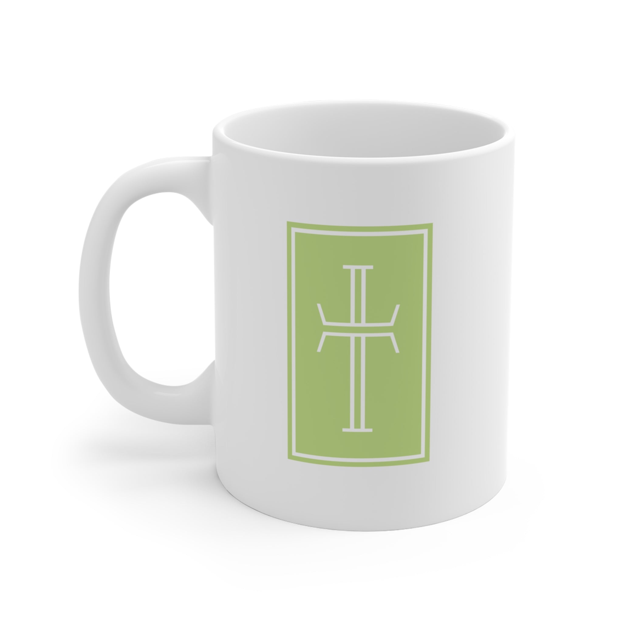 Front of a white mug displaying a white cross against a sunny green background.