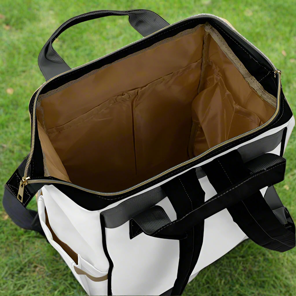 The top open zipper of the diaper bag showing a wide-mouth access and three visible internal pockets.