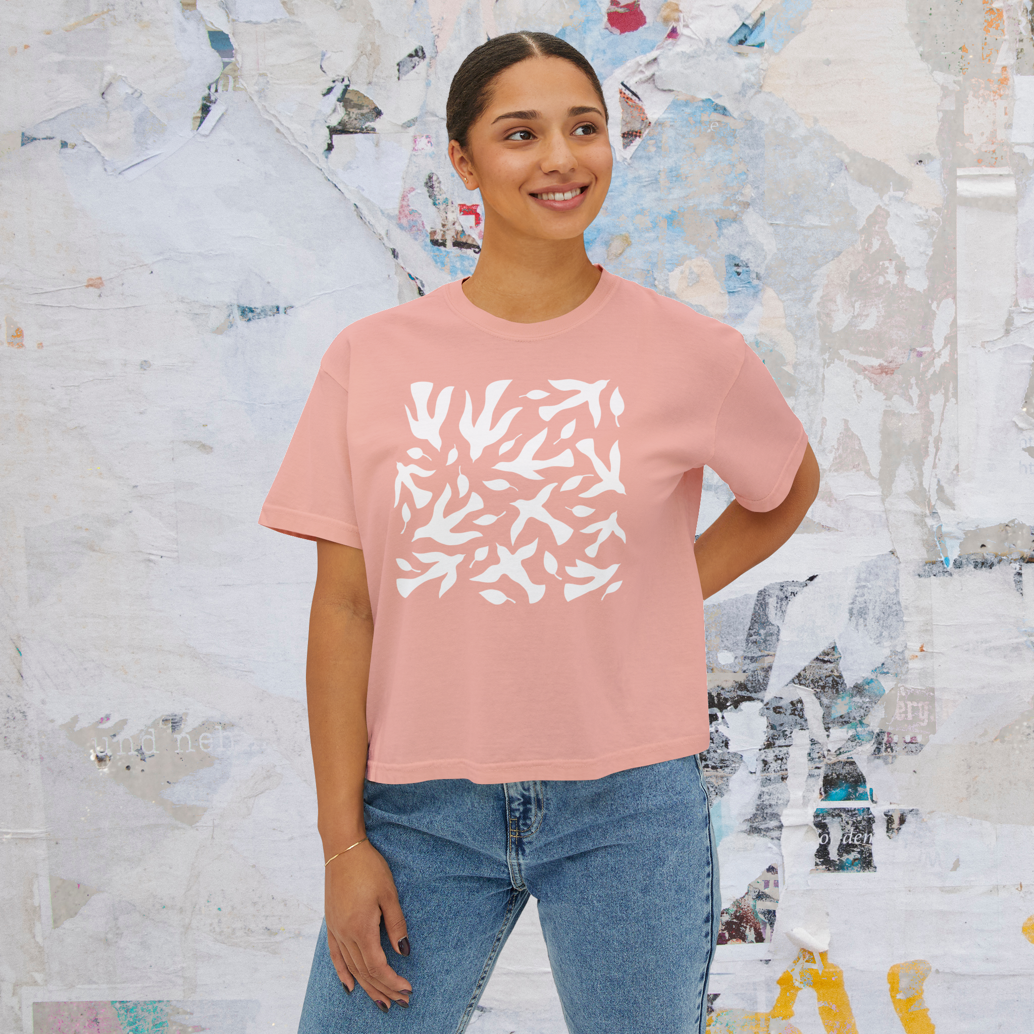 Woman wearing a pink t-shirt with white abstract design on a white background