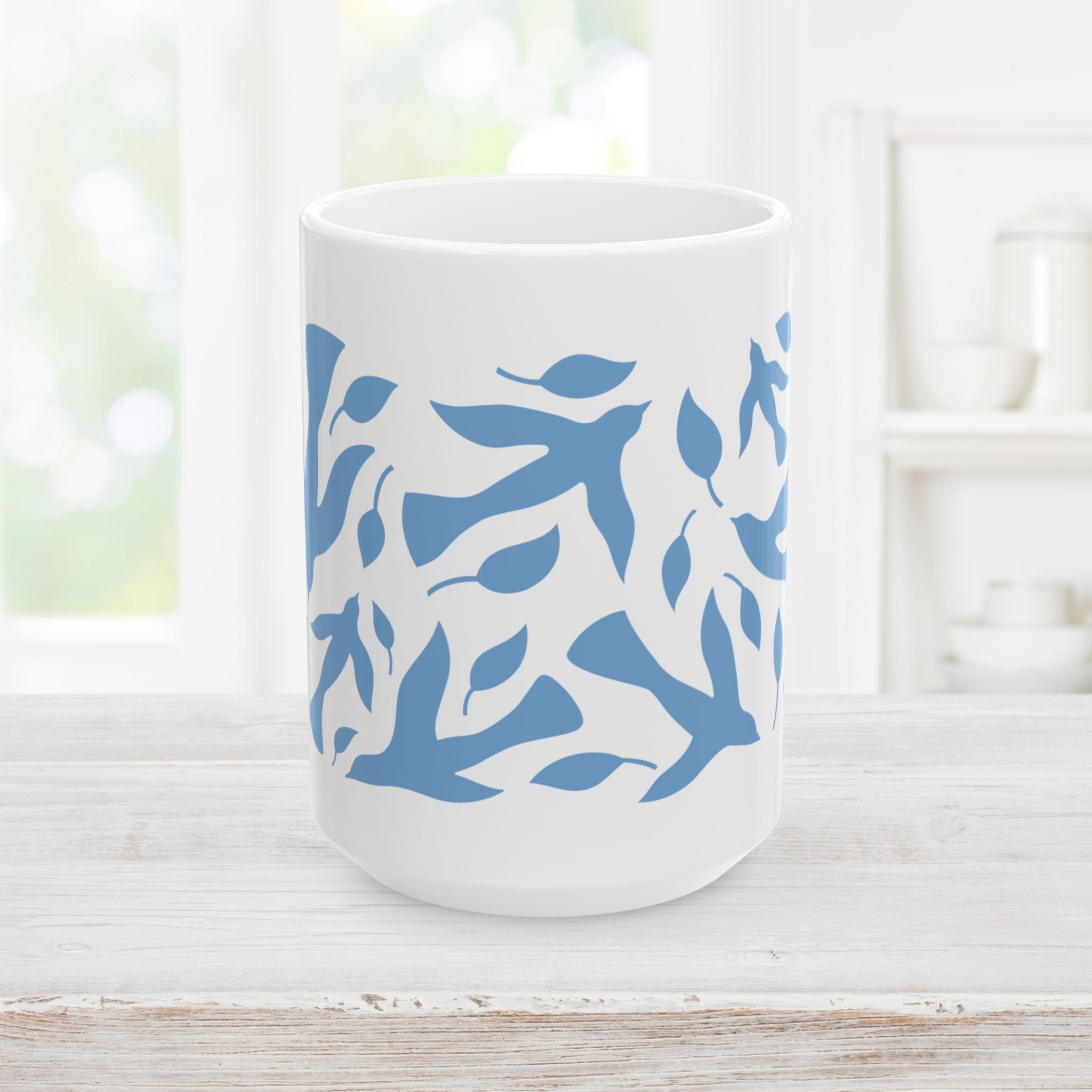 15oz white mug with blue dove and leaf pattern on a wooden surface