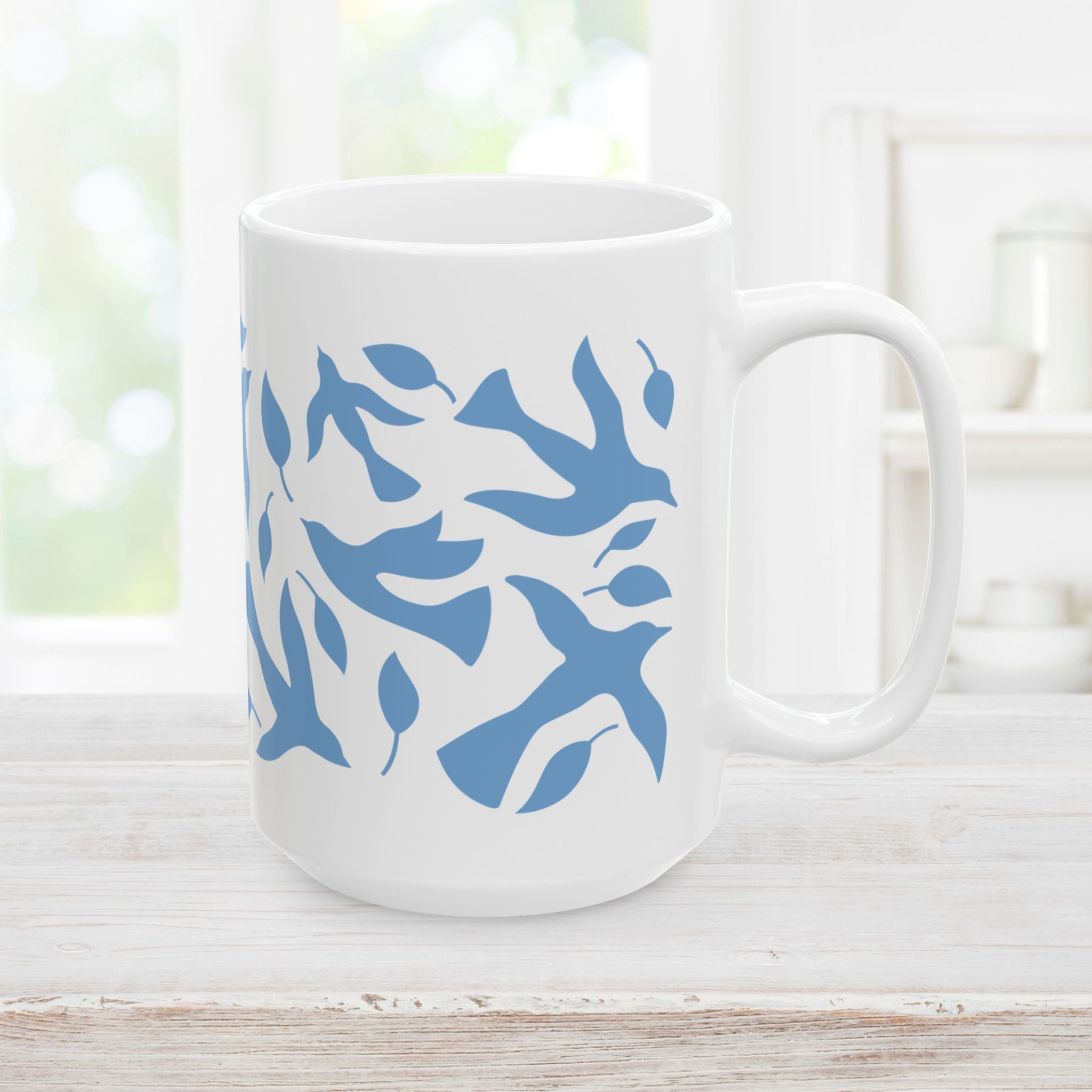 15oz white mug with blue dove and leaf pattern on a wooden surface
