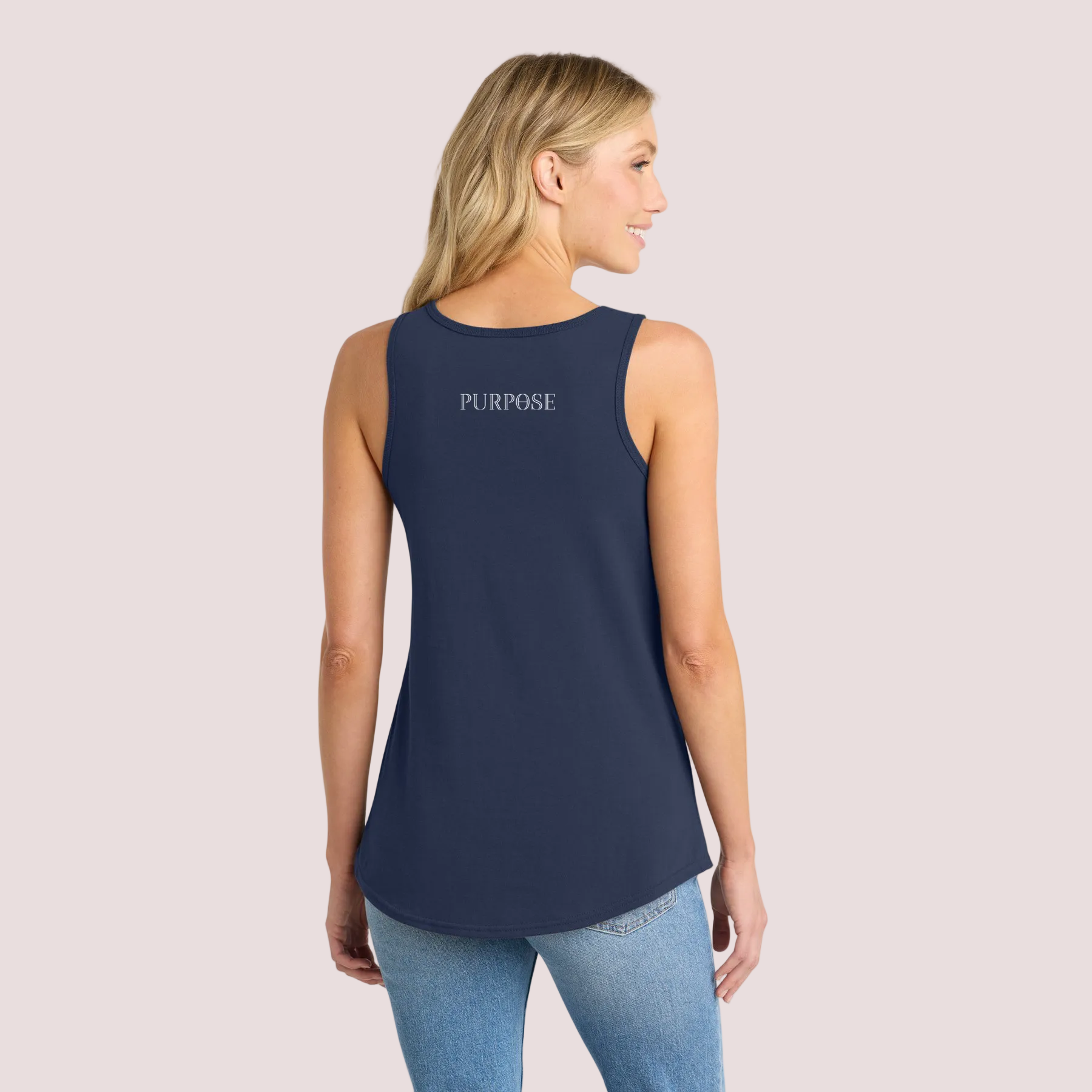 Woman wearing a navy tank top with 'PURPOSE' text on the back, standing against a pale background.