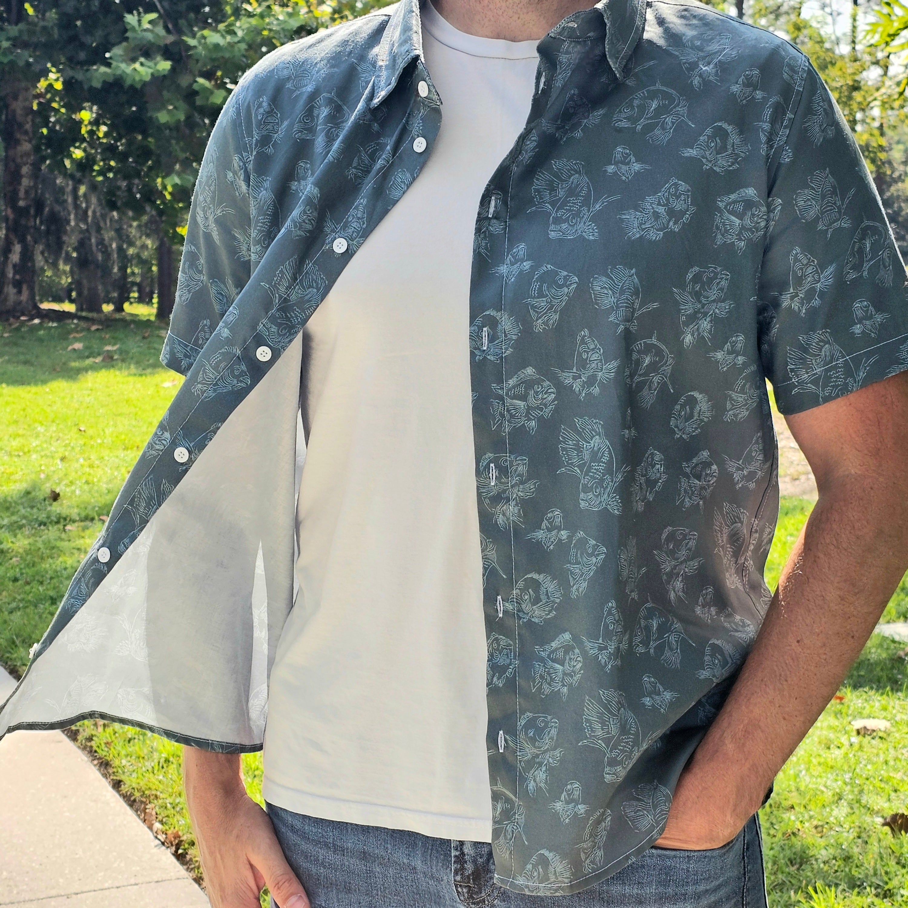 Man wearing a patterned shirt over a plain shirt outdoors