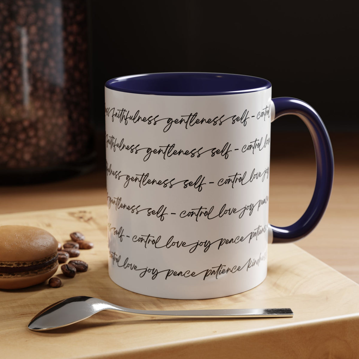 Right side of 15oz mug with navy interior and handle with black scripted text written on a white background sitting on a wooden surface with coffee beans and a spoon.