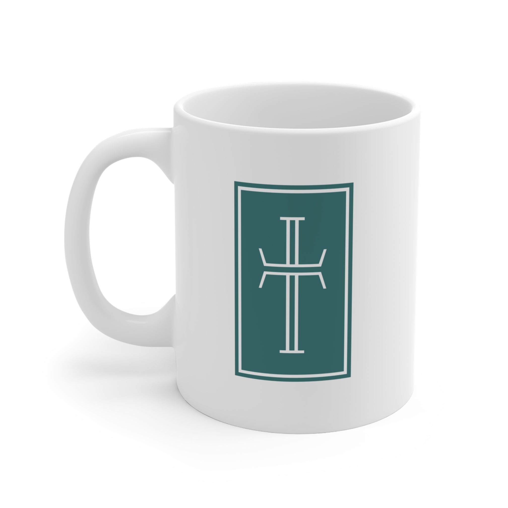 Front of a white mug displaying a white cross against a deep teal background.