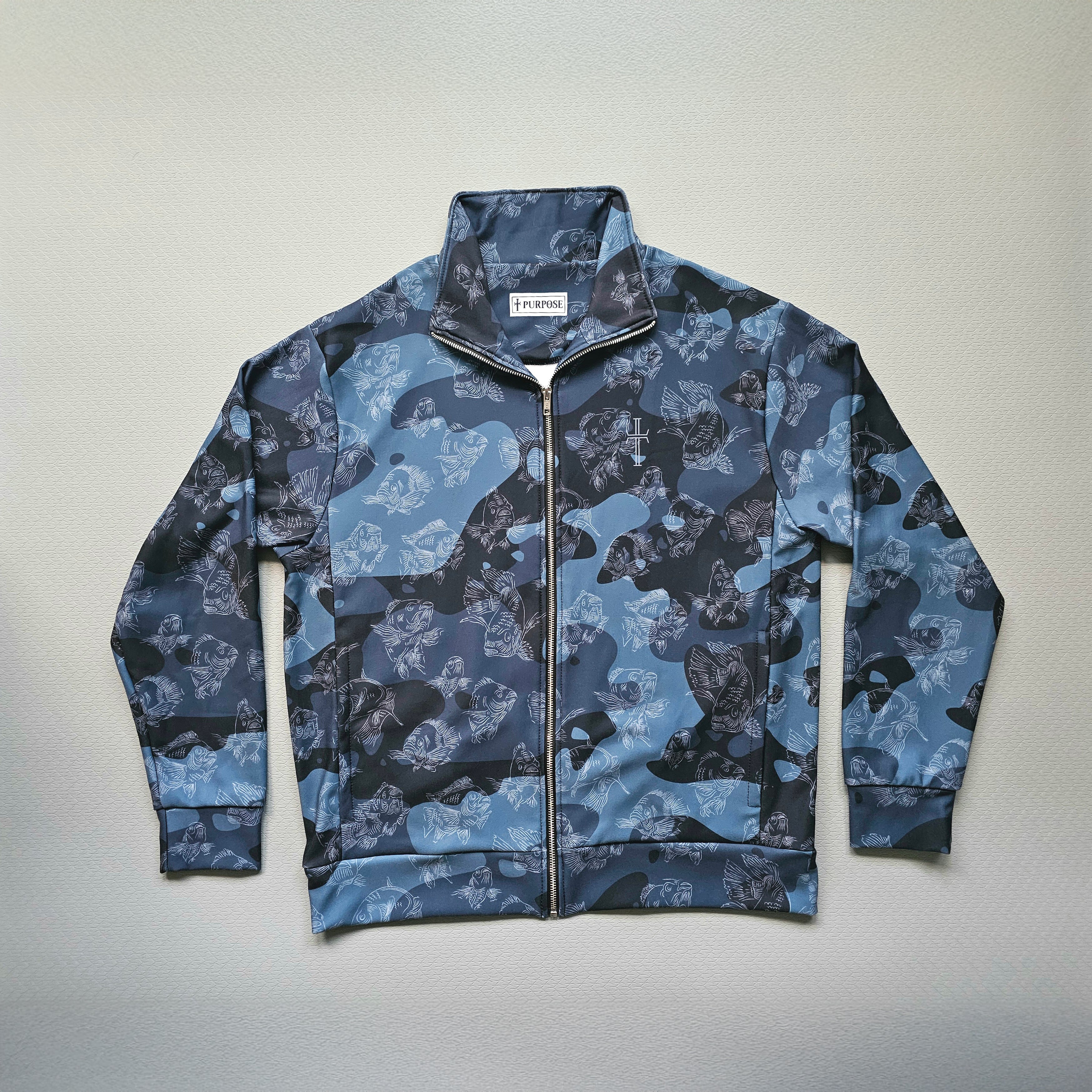 Blue camouflage jacket with swimming carp pattern on a light gray background