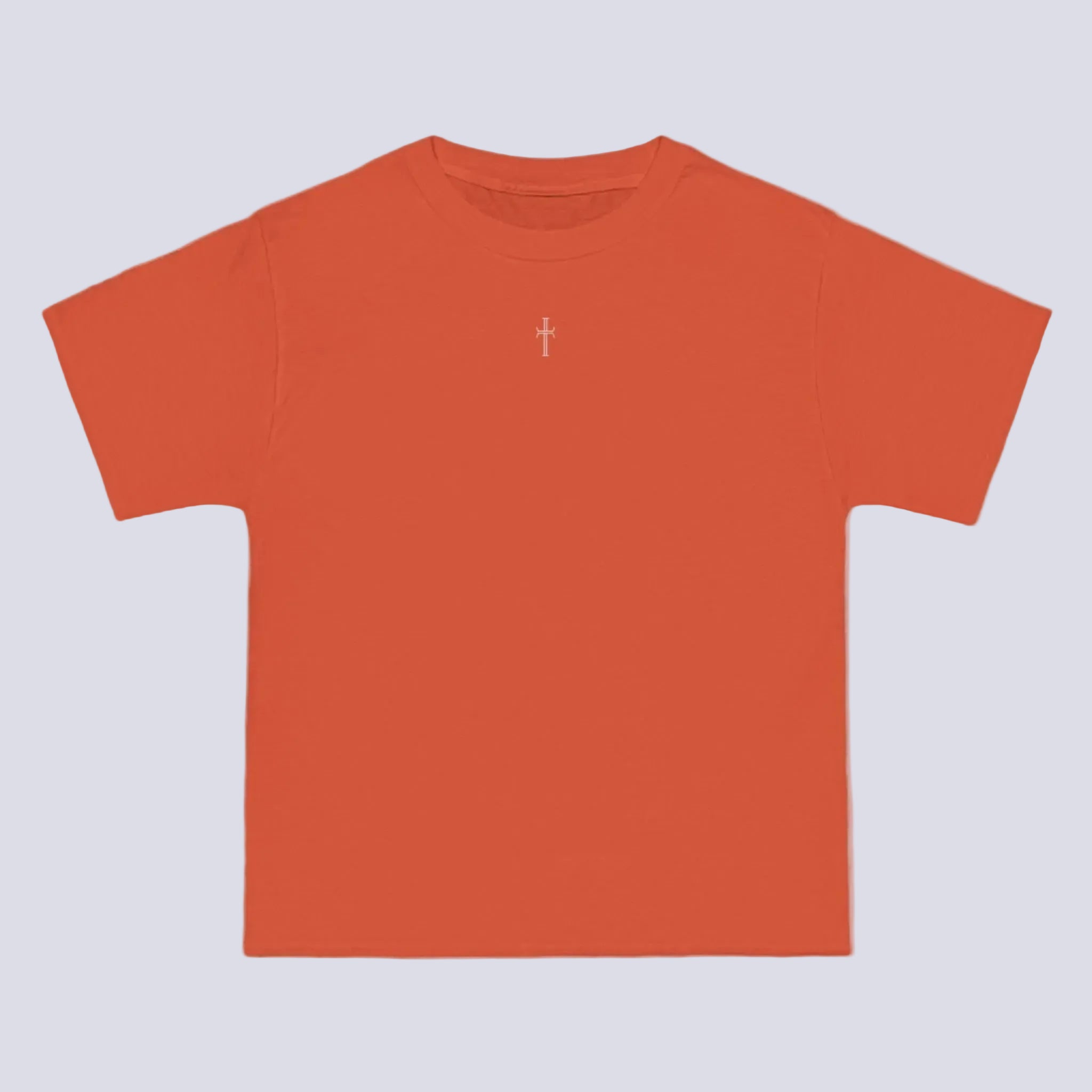 An orange crewneck tee shirt displays the front of the garment. A small white cross logo is printed at the top center.