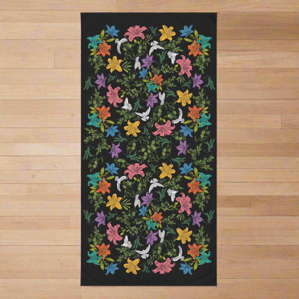 Colorful floral patterned towel laying flat on a wood floor.