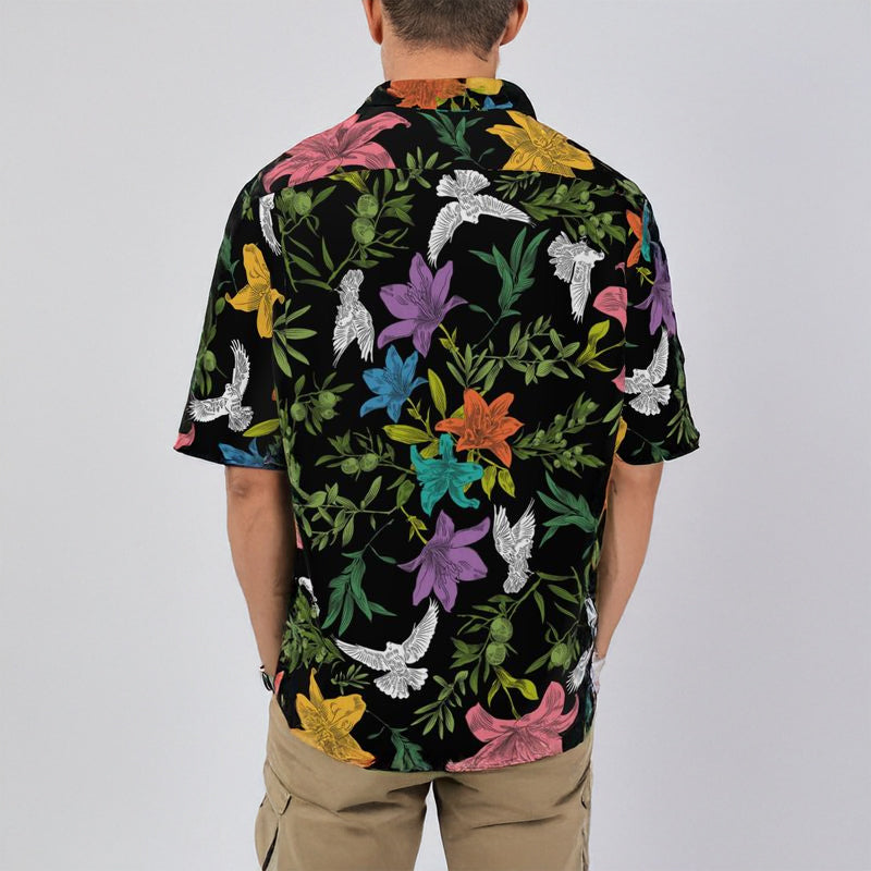 Back of man wearing a black floral patterned shirt against a plain background