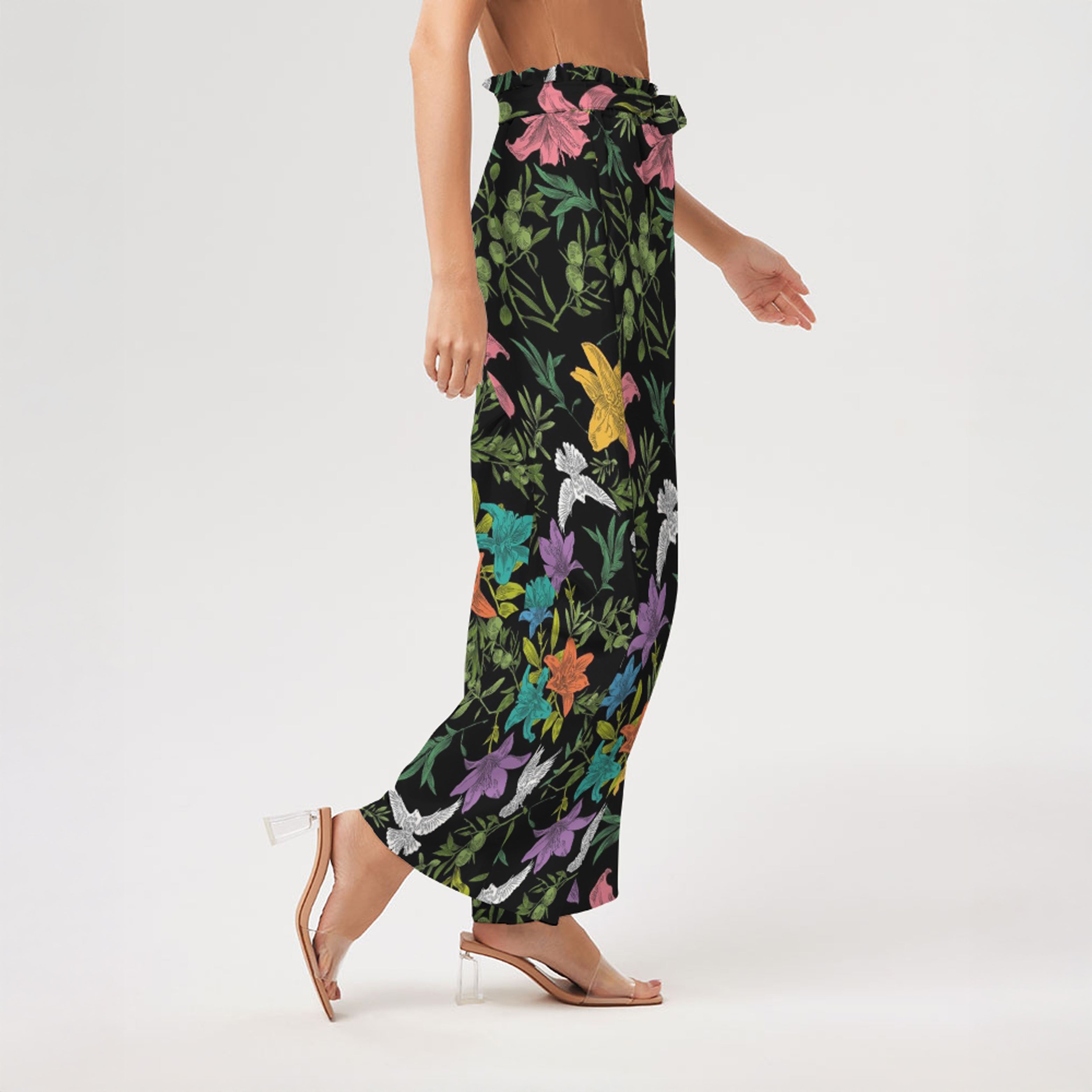 Right side of colorful floral-patterned pants worn by a person on a white background