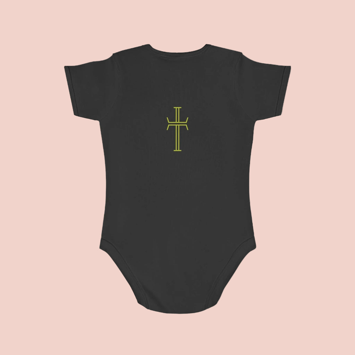 Black baby onesie with a yellow cross design on a pale pink background