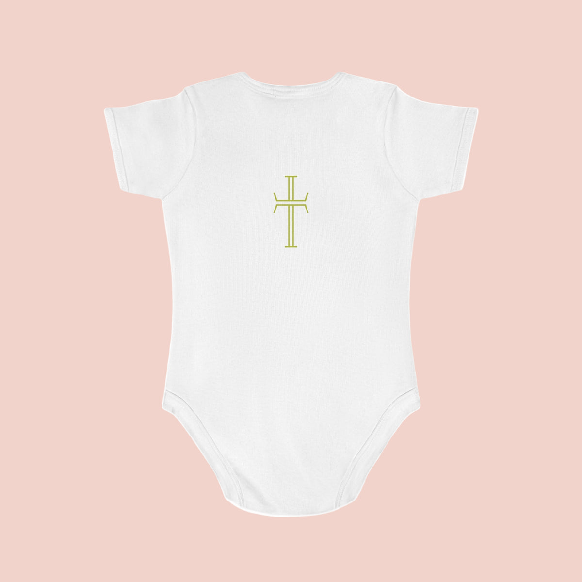 White baby onesie with a yellow cross design on a pale pink background