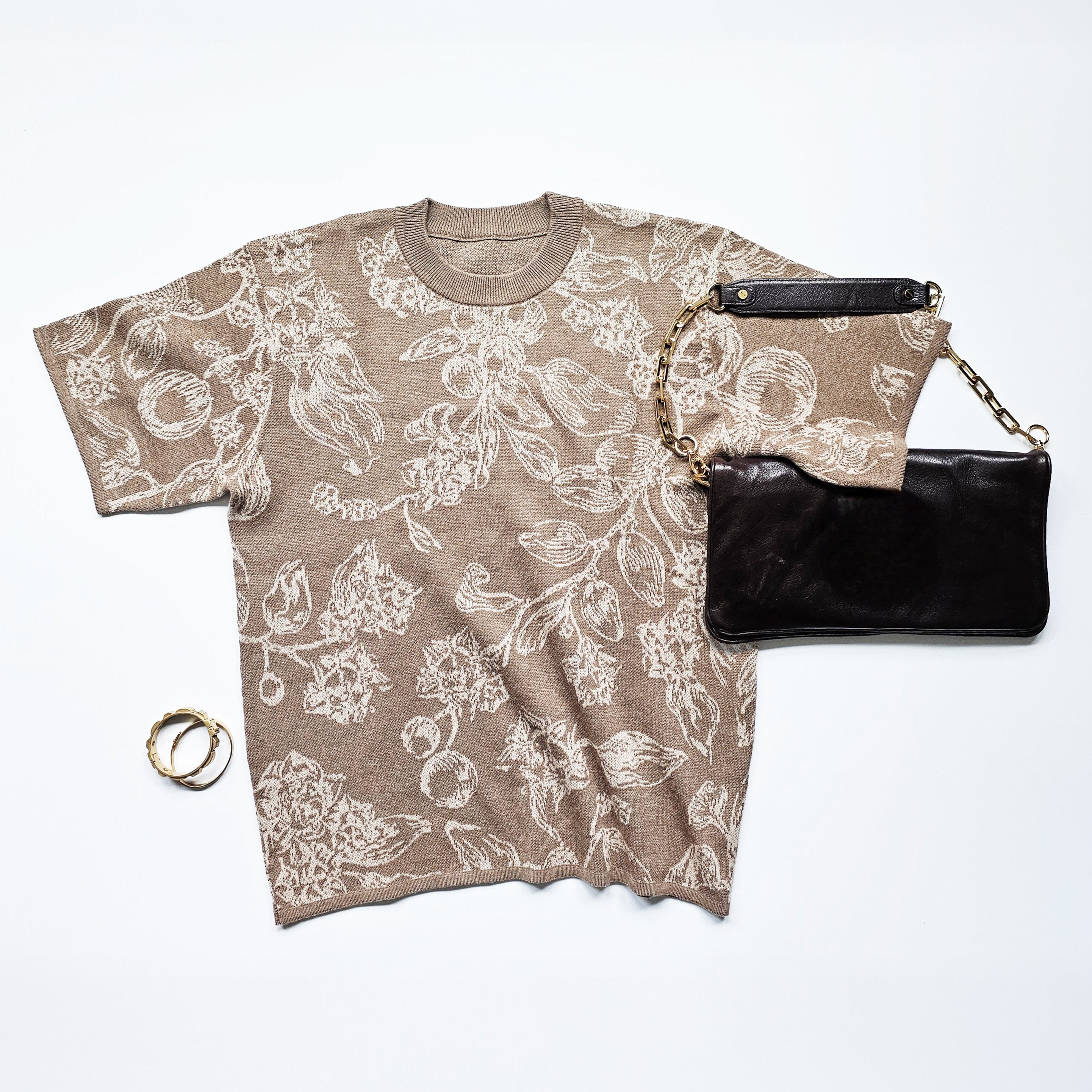 Floral-patterned t-shirt and black clutch bag on a white background