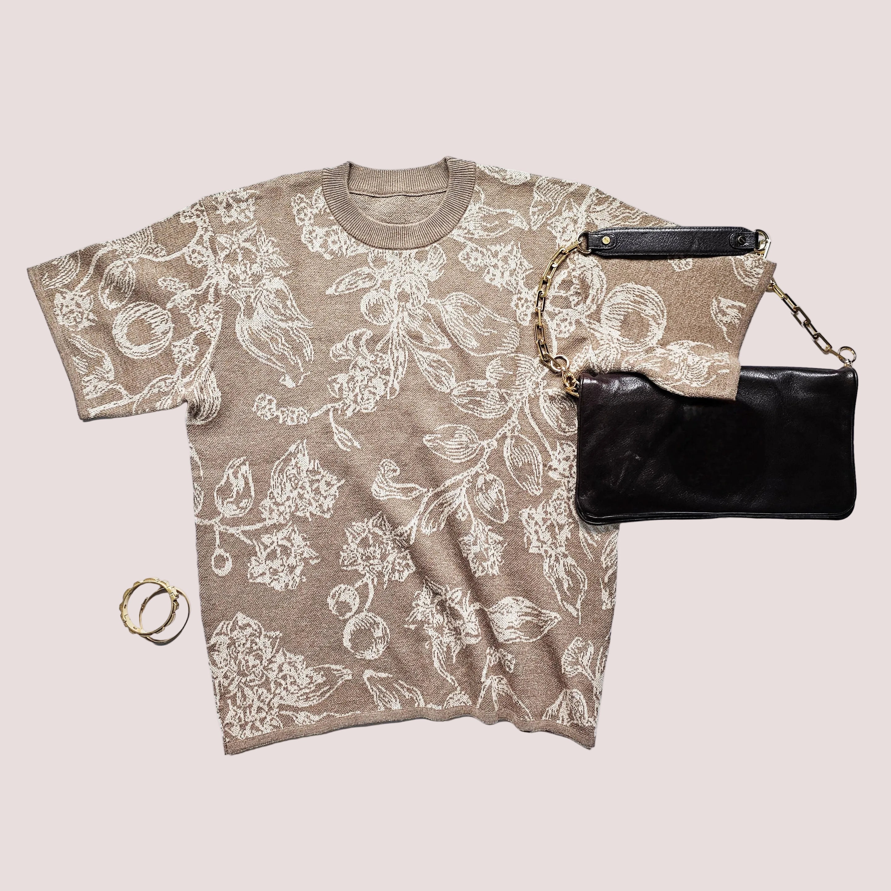 Floral-patterned t-shirt and black clutch bag on a white background