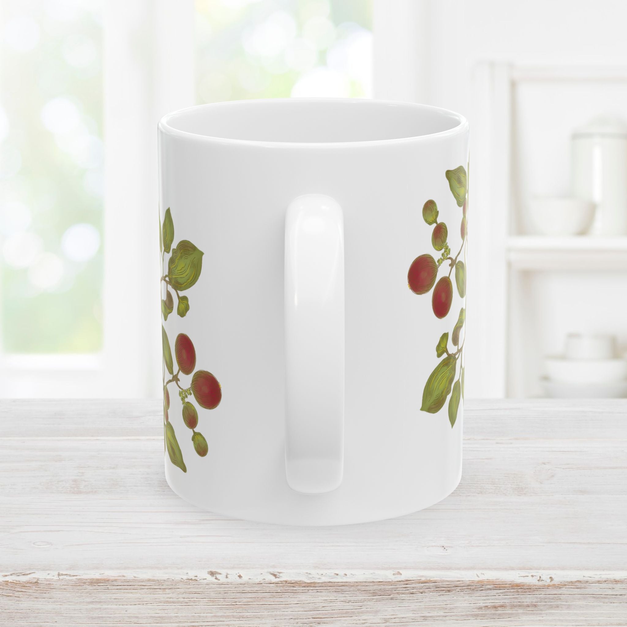 Back side with handle of white mug decorated with florals, berries, and leaf designs on a white surface.