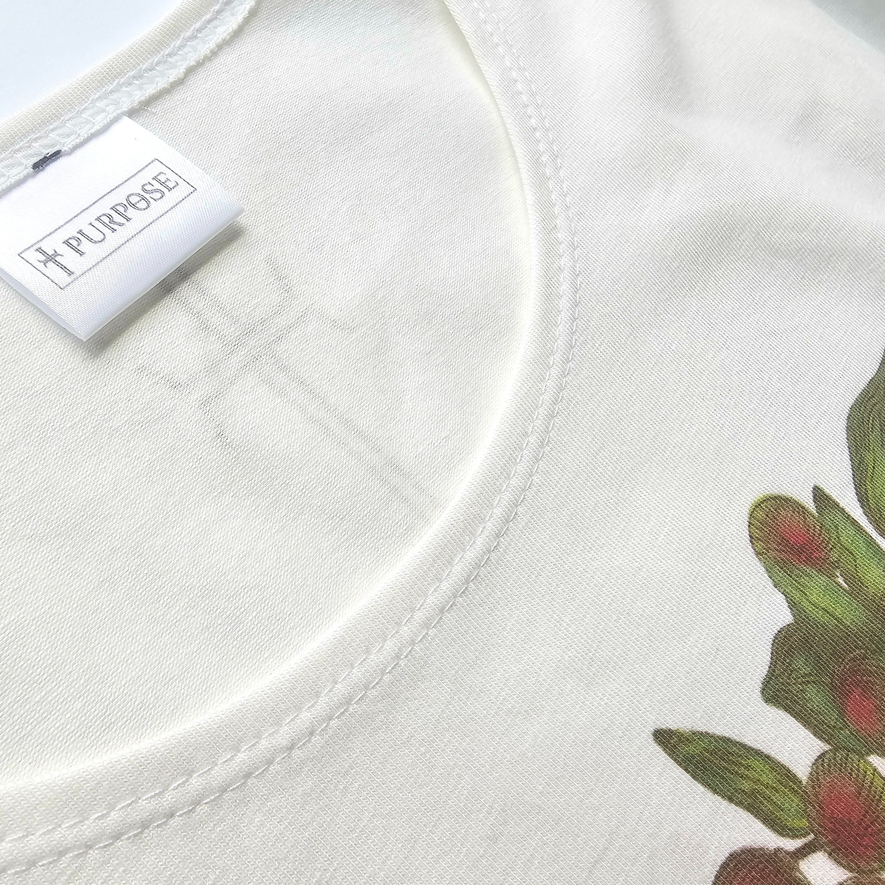 Close-up of a white shirt with floral image and a label on a white background
