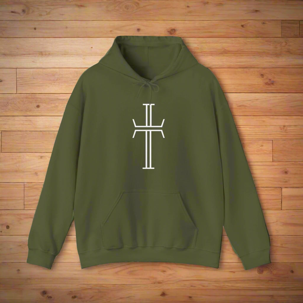 An army green hoodie with a kangaroo pocket, lays against a lays against a wood floor, showing the front of the garment with the bold white Purpose cross logo across the chest.