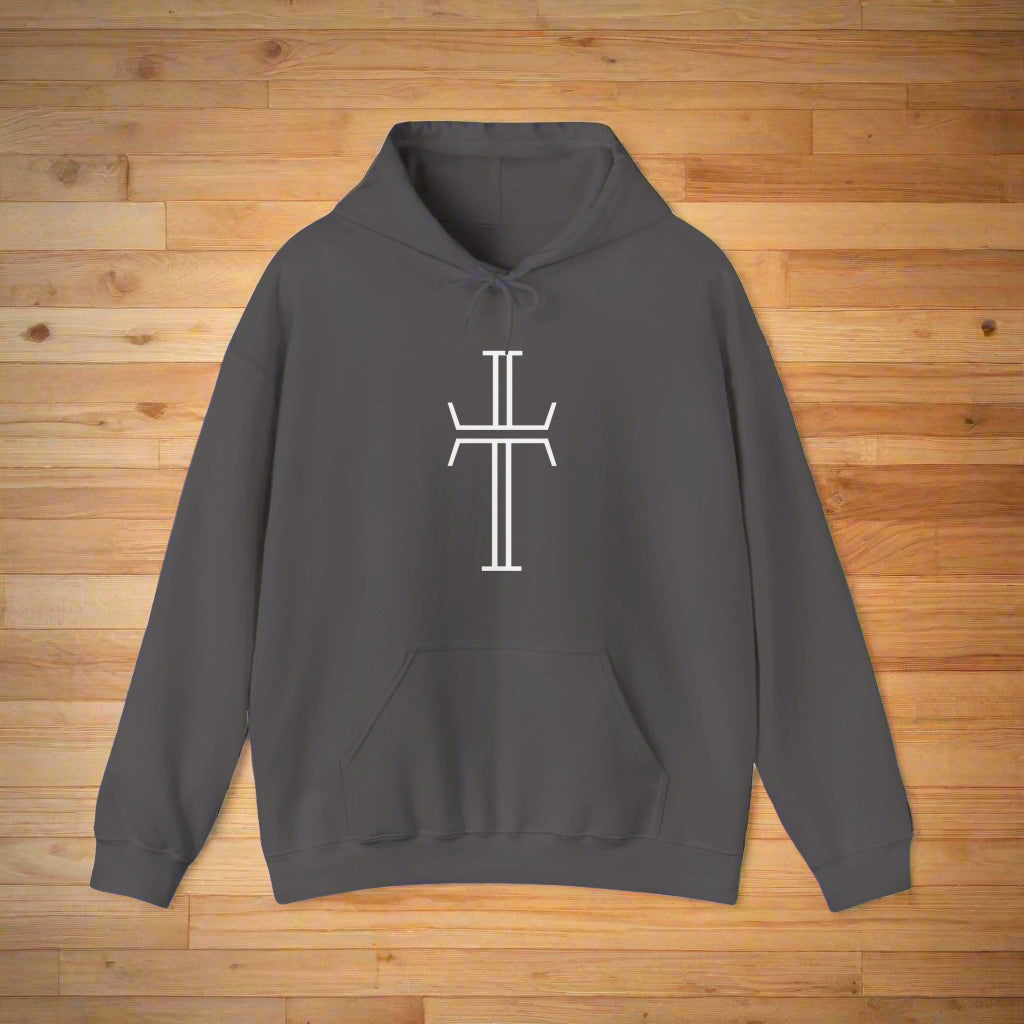 A gray hoodie with a kangaroo pocket, lays on a wood floor, showing the front of the garment with the bold white Purpose cross logo across the chest