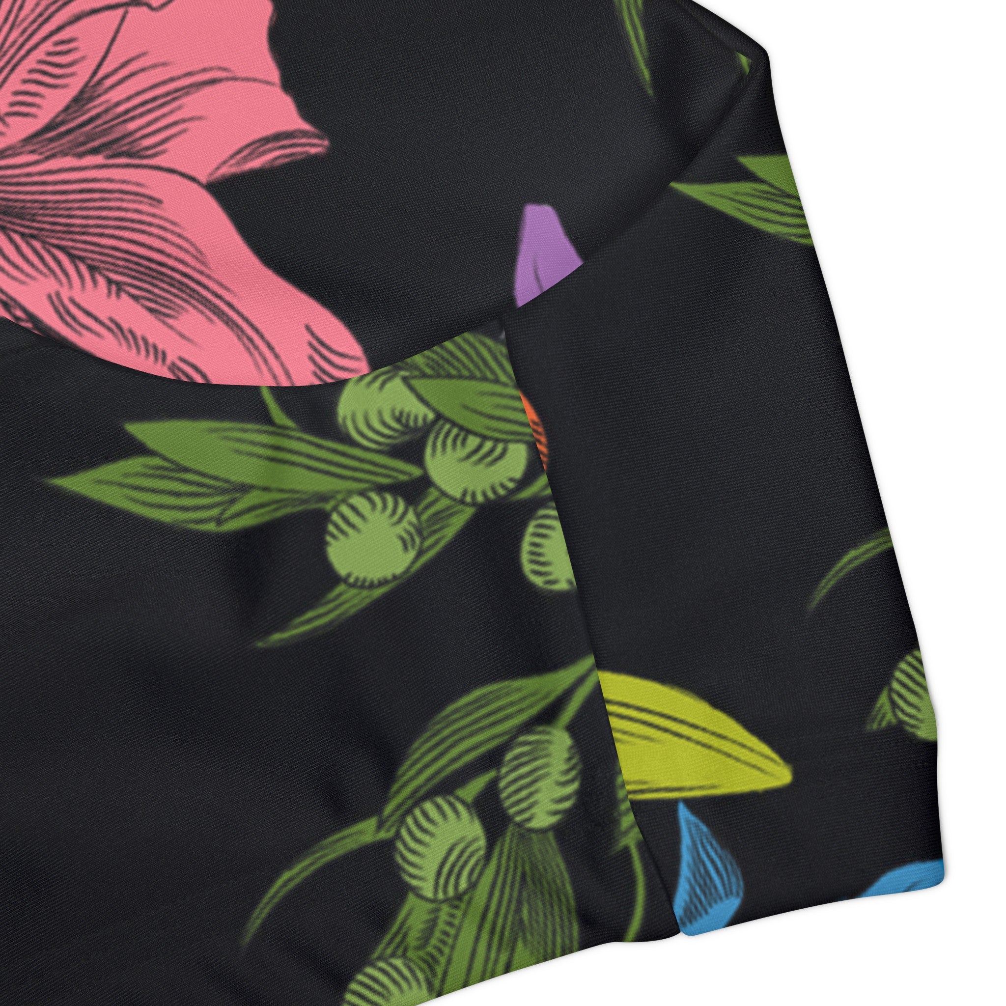 Close-up of the side of the tank swim top showing the finer details of the all-over, multi-colored pattern with flowers, olive branches, and doves. 