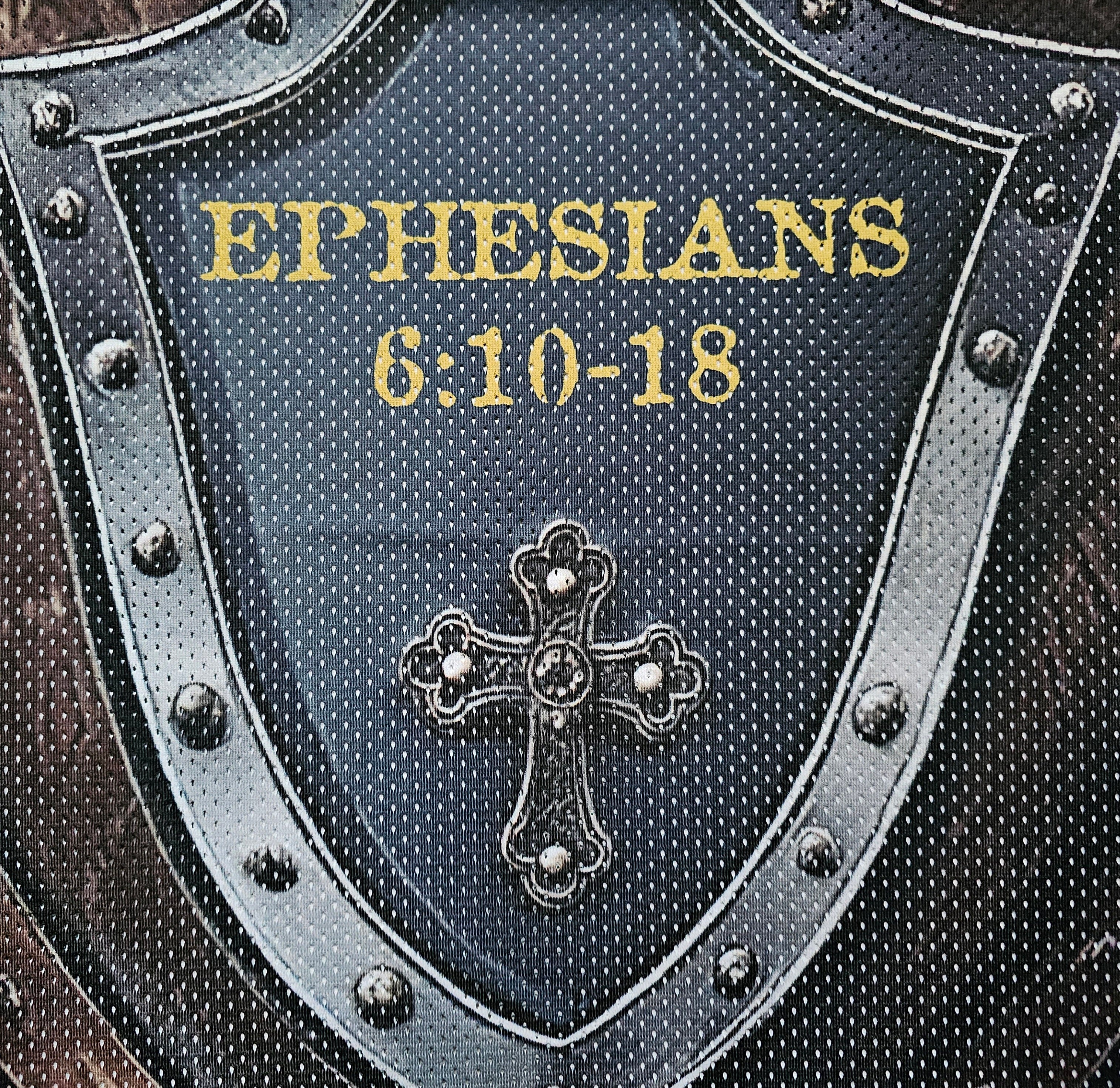 Shield-shaped image on football jersey with 'Ephesians 6:10-18' text and cross emblem