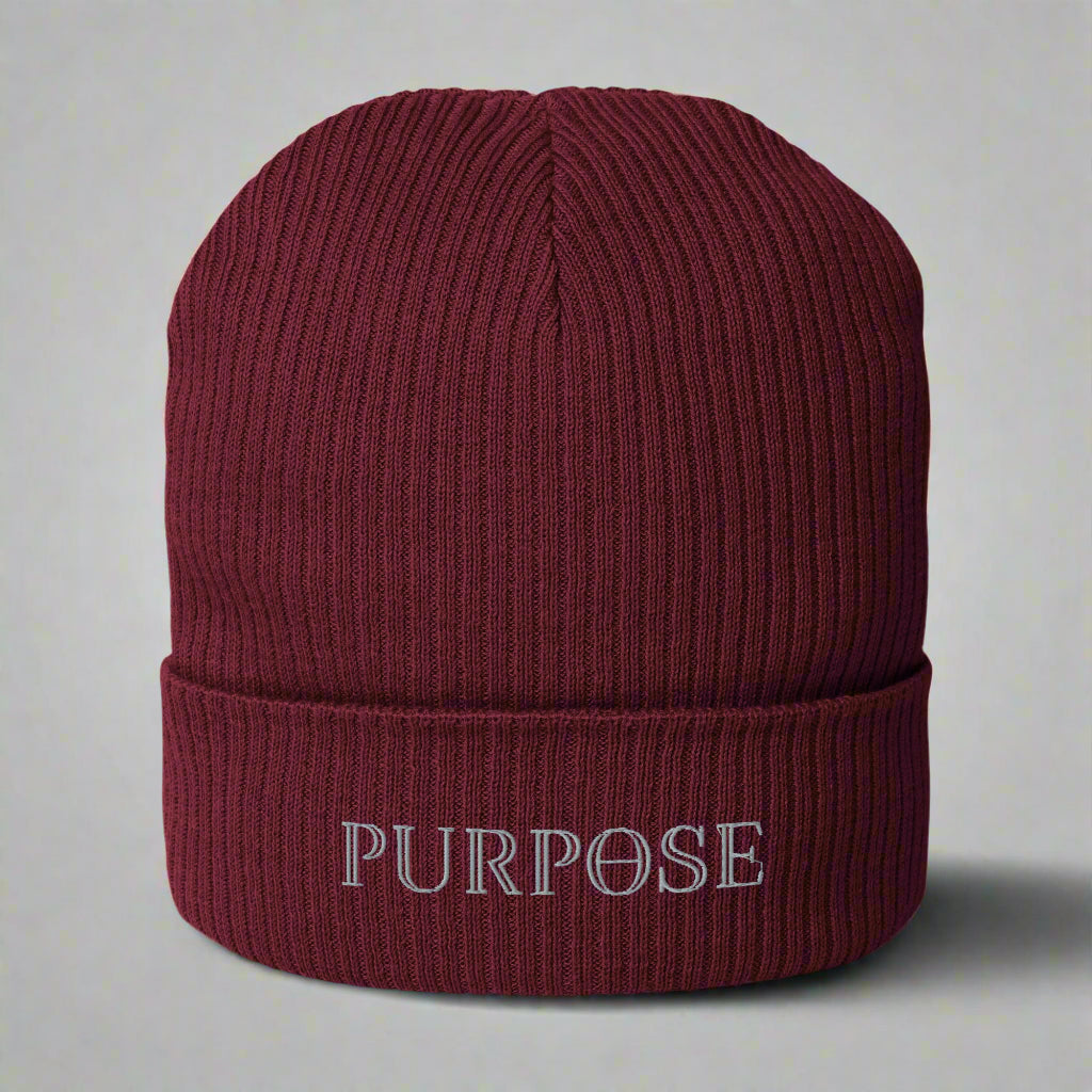 Maroon beanie with 'PURPOSE' embroidery on a light gray background