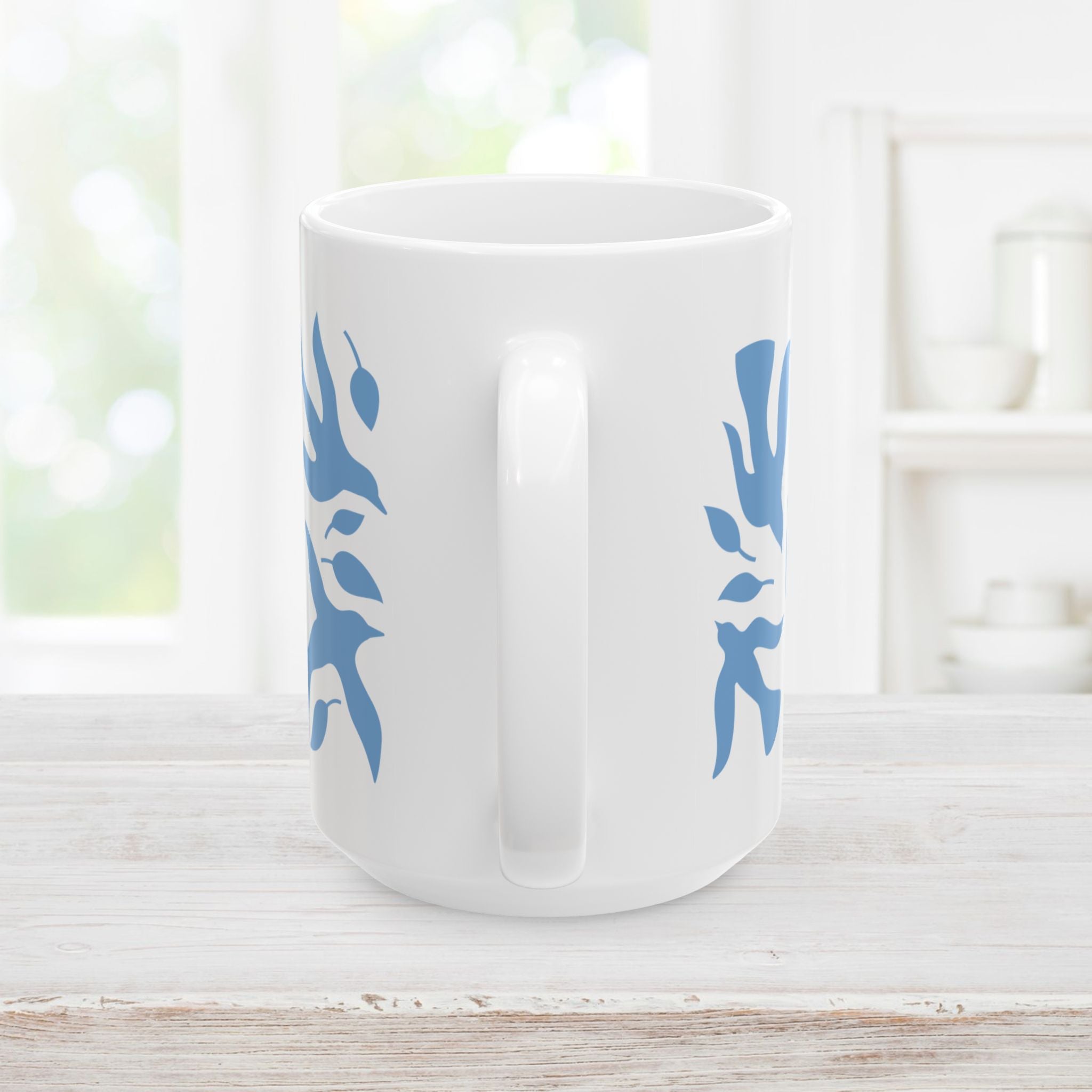 15oz white mug with blue dove and leaf pattern on a wooden surface