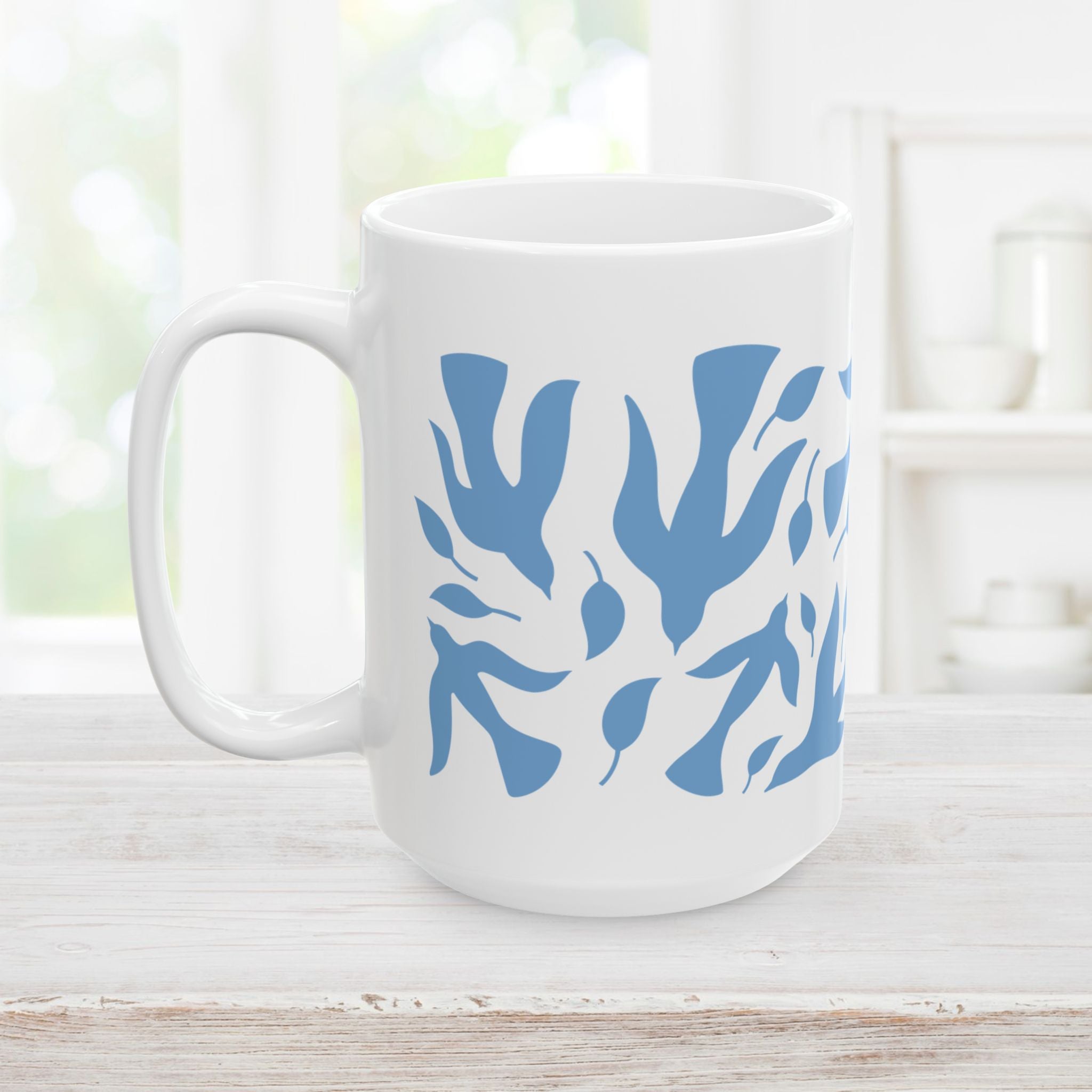 15oz white mug with blue dove and leaf pattern on a wooden surface