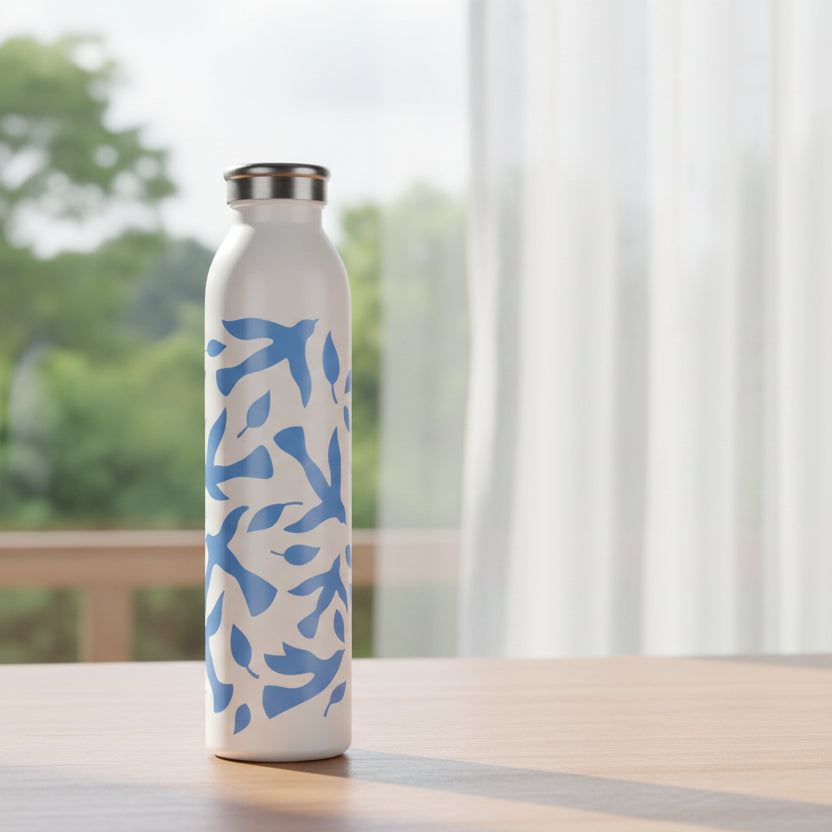 White water bottle with blue dove pattern on a table next to window