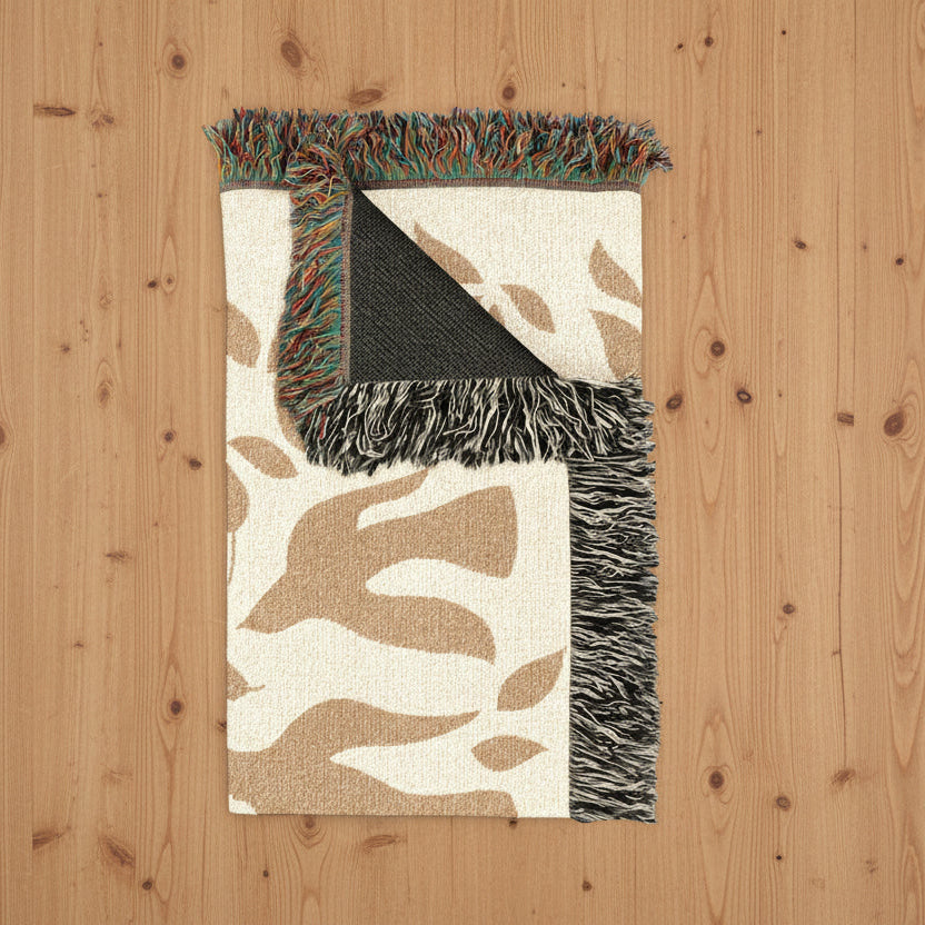 Leaf and dove patterned rug with fringe on a wood floor