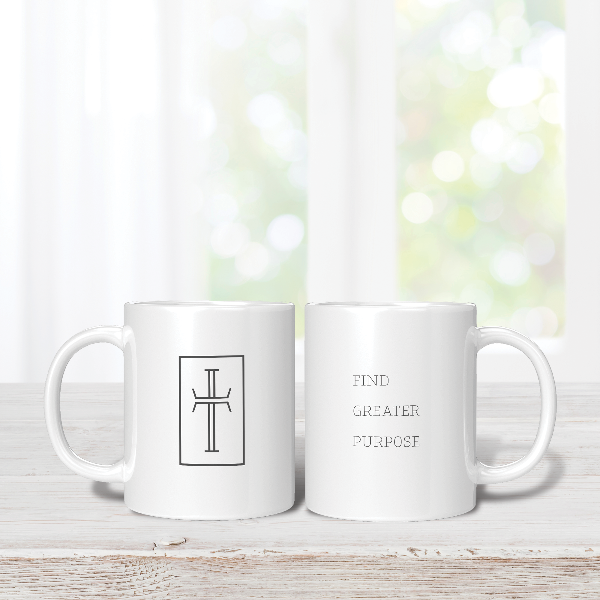 Two white 11oz mugs with a cross on the front and Find Greater Purpose text on the back. Both mugs are on a wooden surface with a blurred natural background.