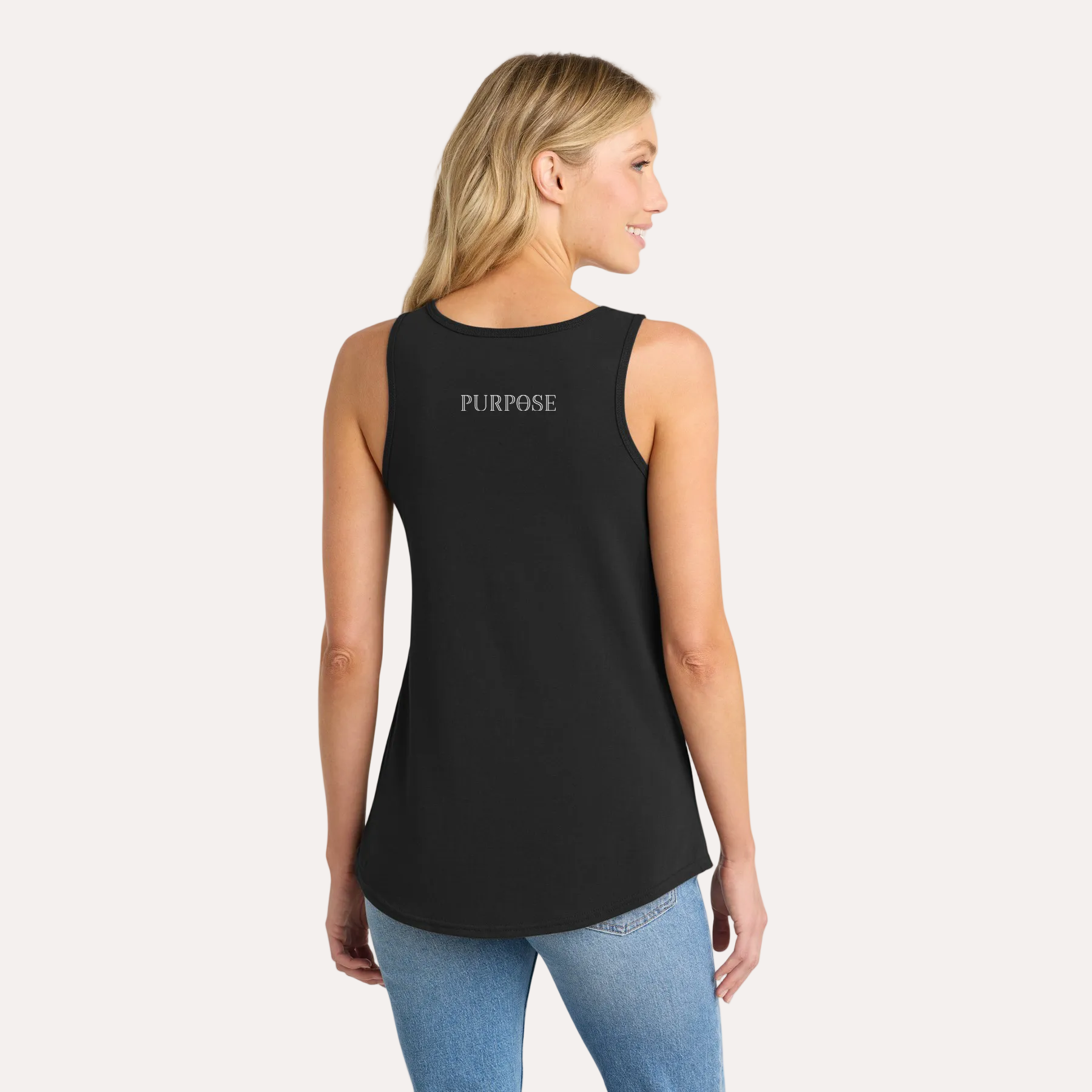 Woman wearing a black sleeveless top and blue jeans on a white background