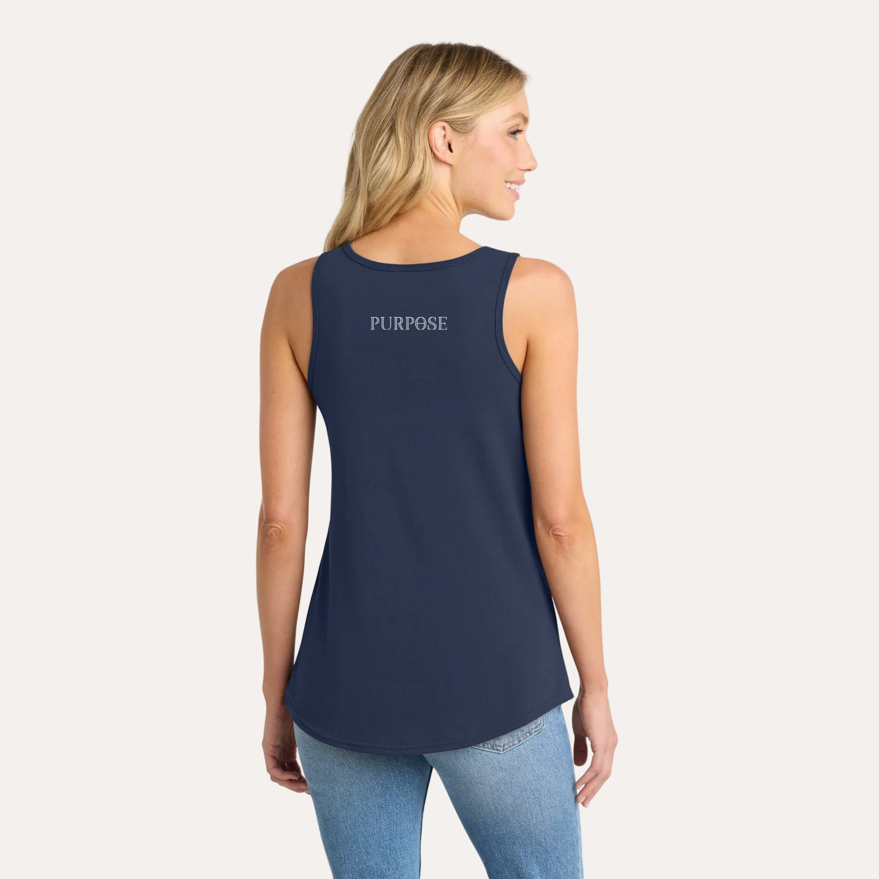 Woman wearing a navy tank top with 'PURPOSE' text on the back, standing against a white background.
