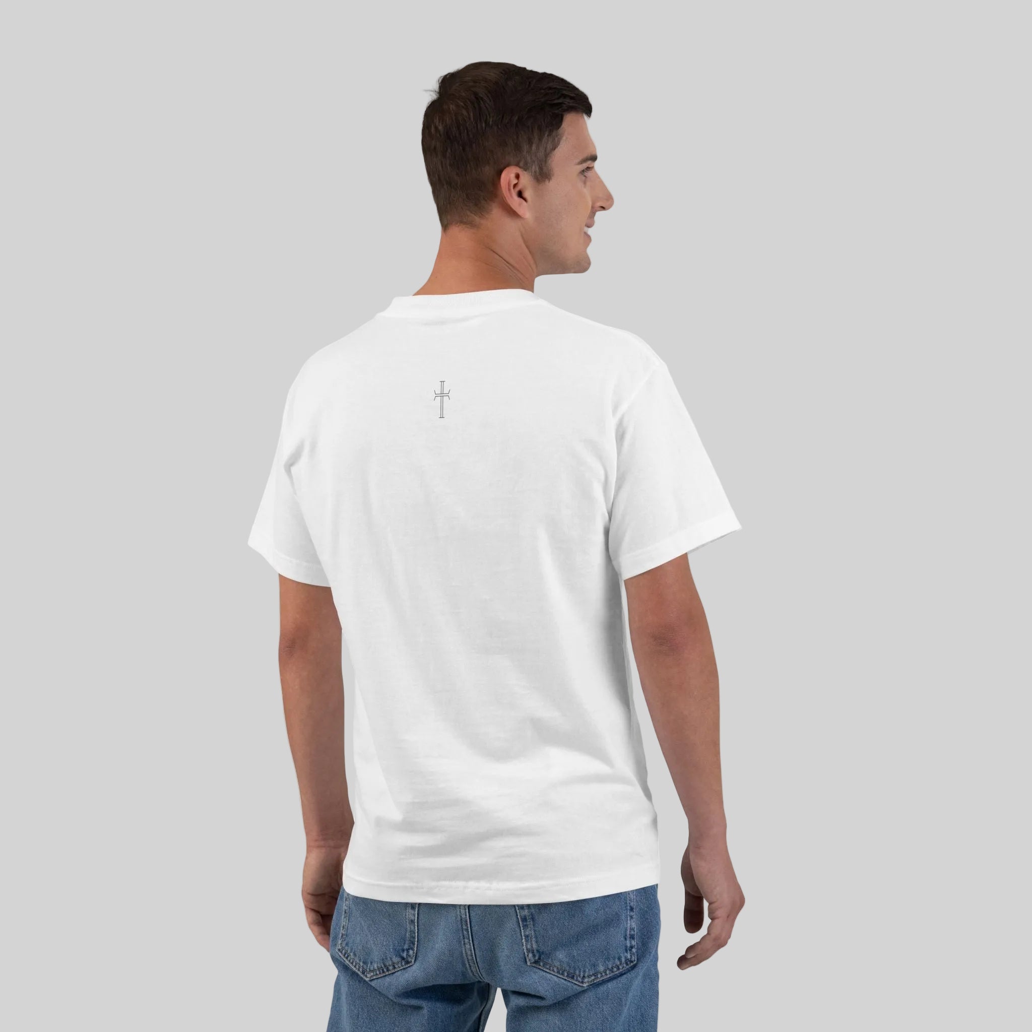 Back of man wearing a plain white t-shirt with a cross on upper back with blue jeans on a gray background