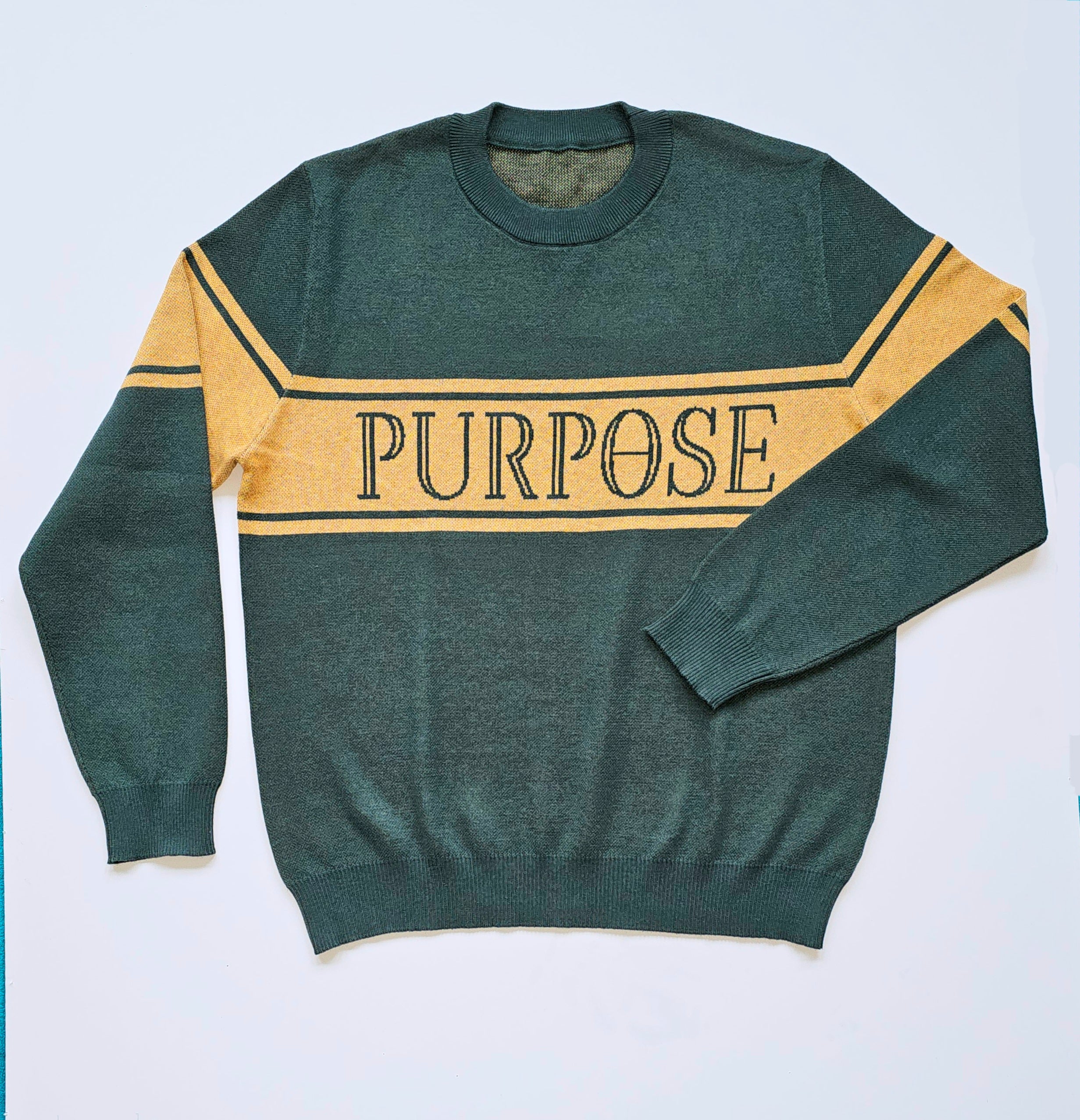 The forest green sweater is laying against a white background. The three mustard-colored stripes across the center chest and upper arms are displayed. The word "Purpose" in forest green capital letters on the center of the chest is depicted.