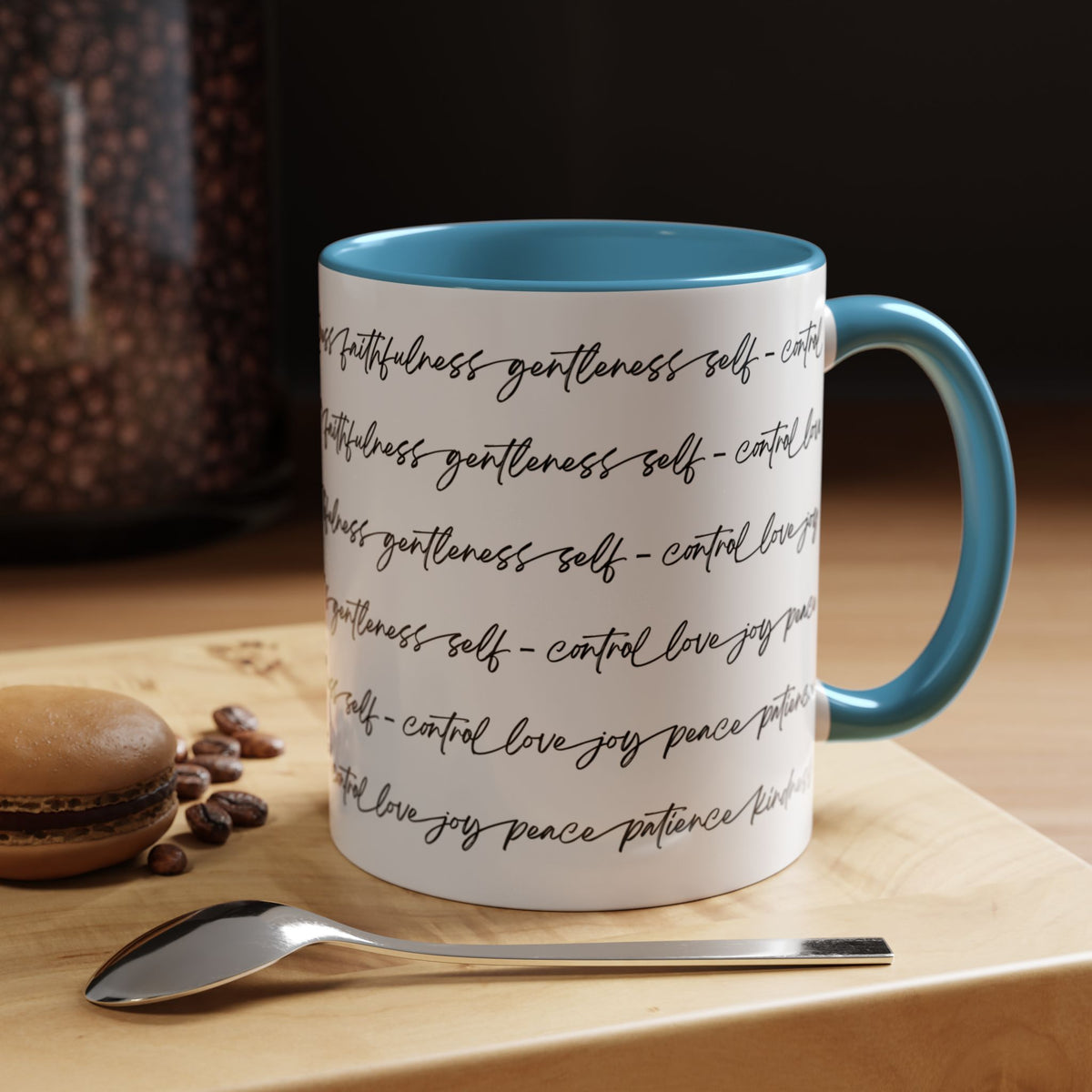Right side of 11oz mug with light blue interior and handle with black scripted text written on a white background sitting on a wooden surface with coffee beans and a spoon.