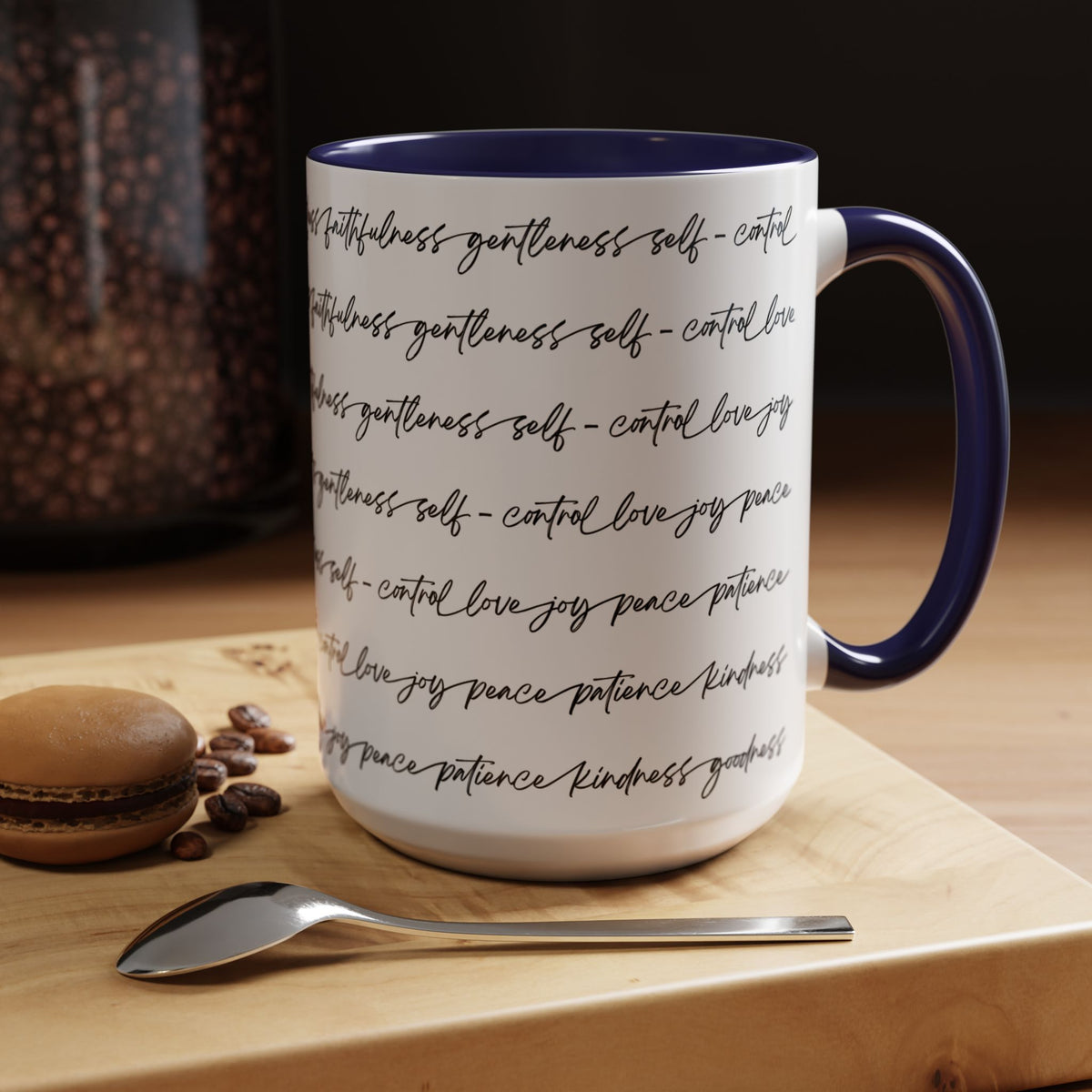 Right side of 15oz mug with navy interior and handle with black scripted text written on a white background sitting on a wooden surface with coffee beans and a spoon.