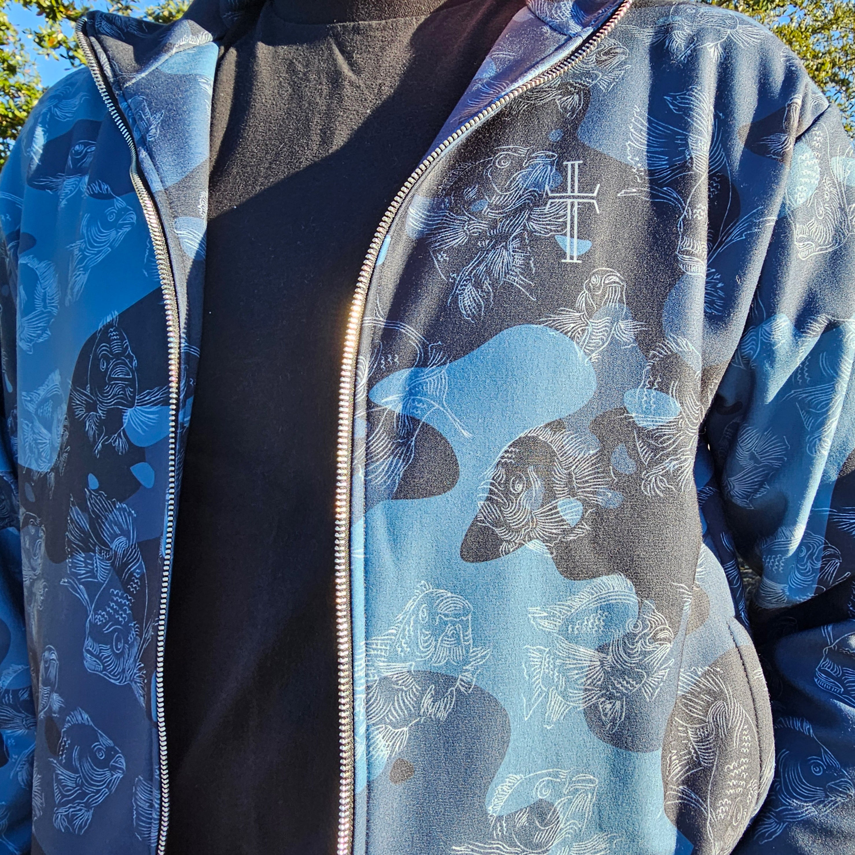 Blue and gray patterned jacket with a cross design on a person wearing it outdoors.