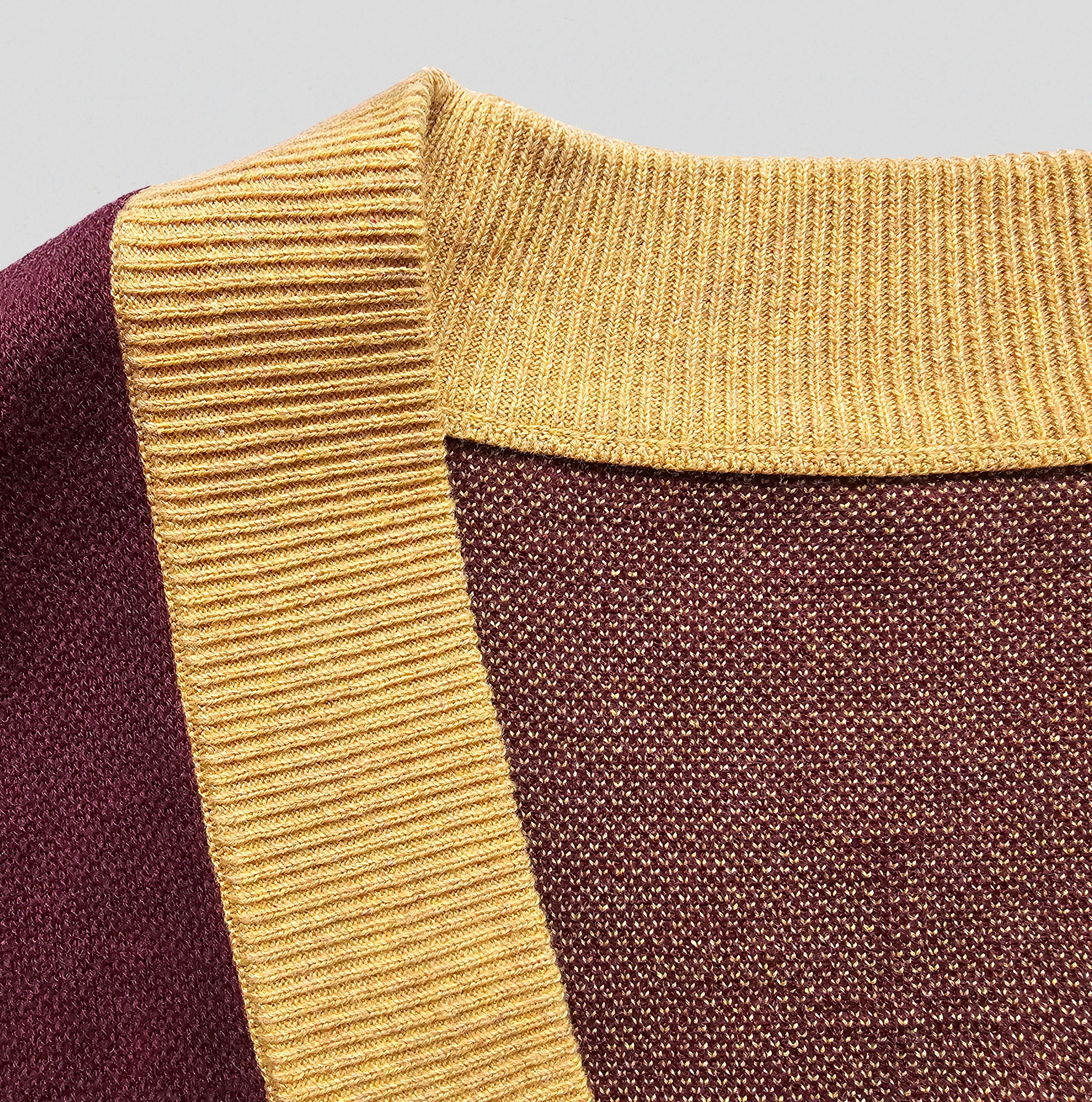 Close-up of a textured fabric with gold and brown colors on a gray background