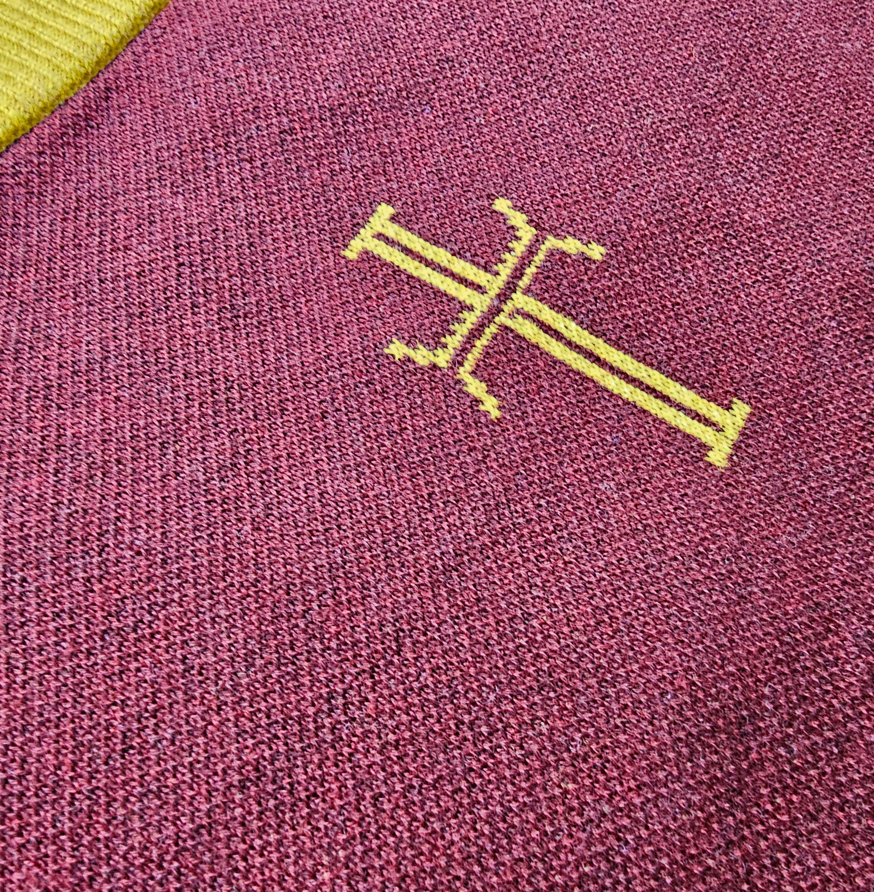 Close-up of a textured purple fabric with a yellow logo.