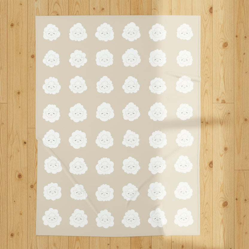 Beige blanket with white lamb pattern on wood floor