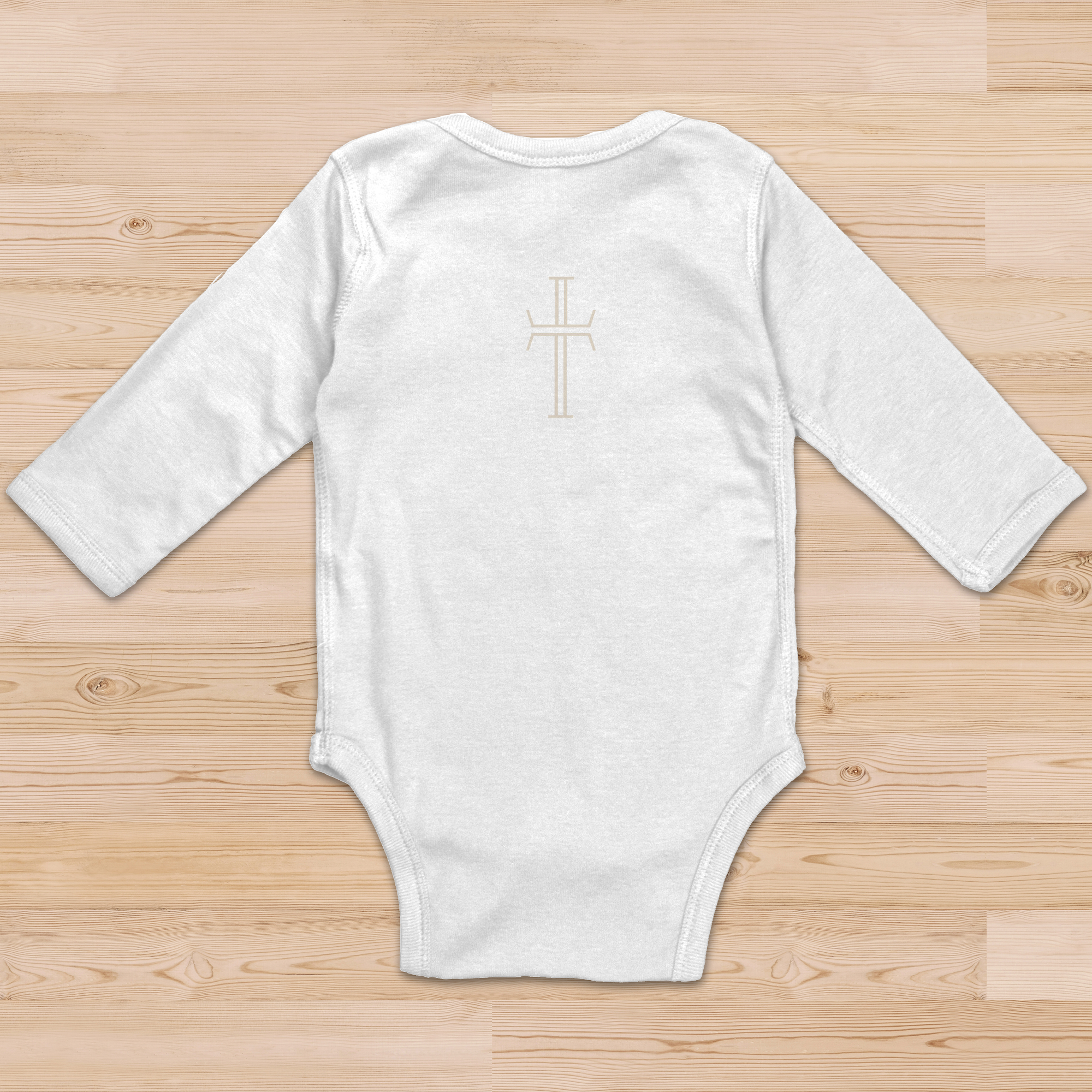 The back view of a white baby onsie has a beige Purpose cross logo on the center back of the garment.