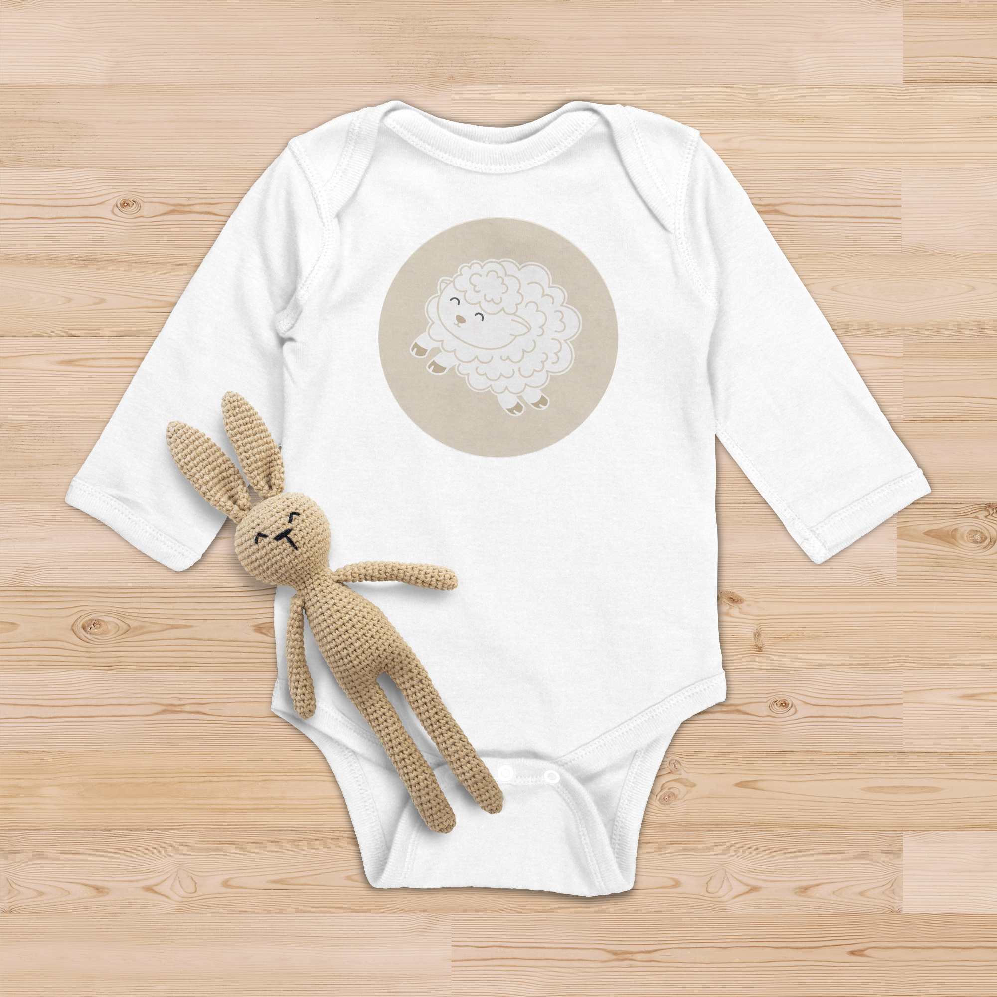 A white baby onsie with a cartoon-style, white, baby lamb in the middle of a large beige circle, is at the center front of the garment.