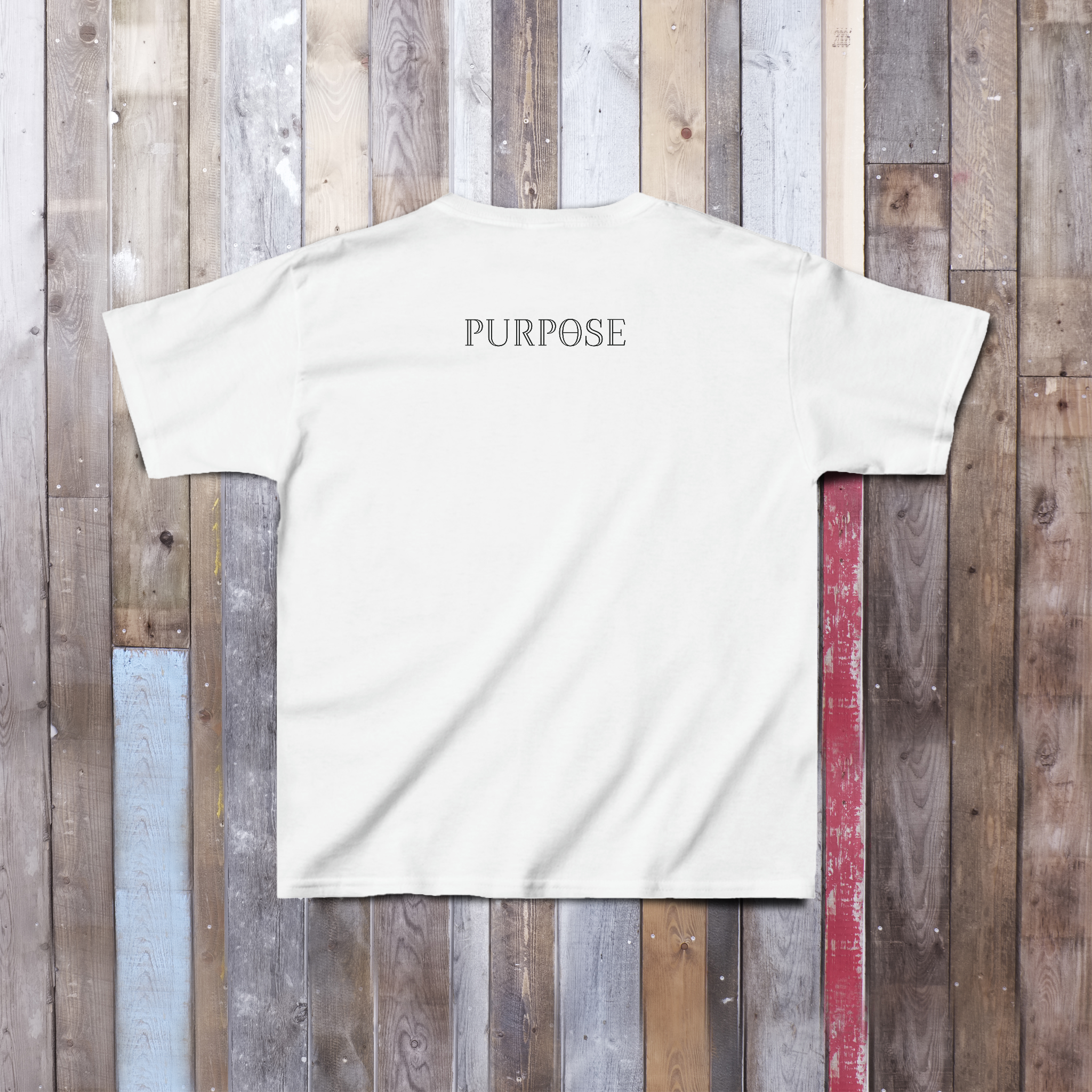 The back of a white tee shirt displays the Purpose worded logo, centered on the back upper portion of the garment.