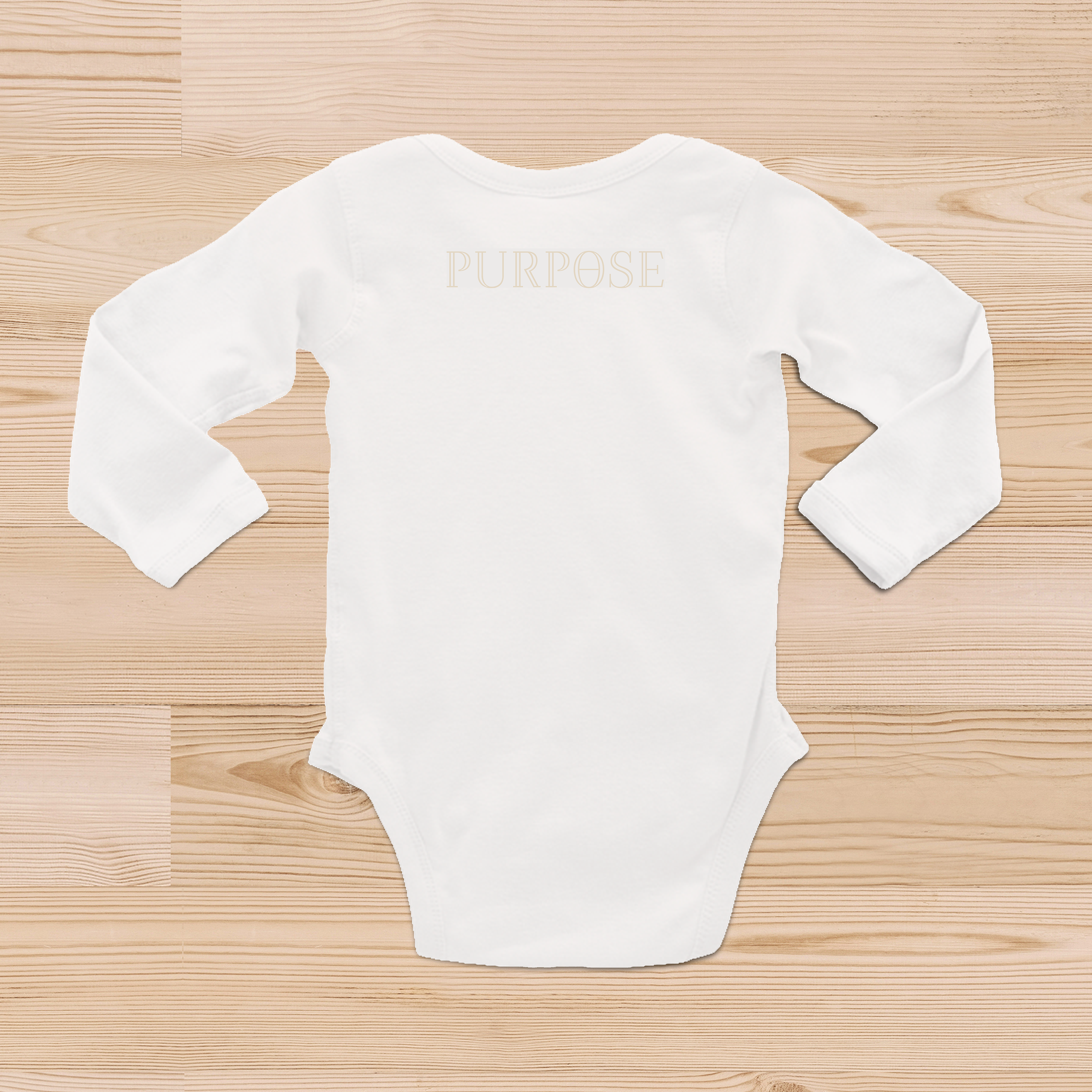 The back view of a white baby onsie with a beige Purpose worded logo on the top center back of the garment.