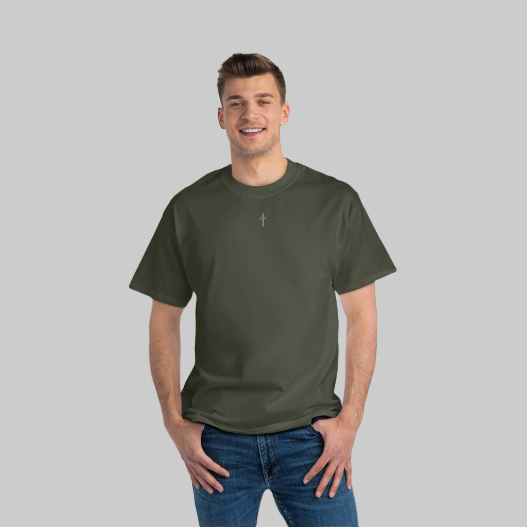 A tall slender man in blue jeans is broadly smiling while wearing a roomy army green crewneck tee shirt with the small Purpose cross logo centered on the upper chest.